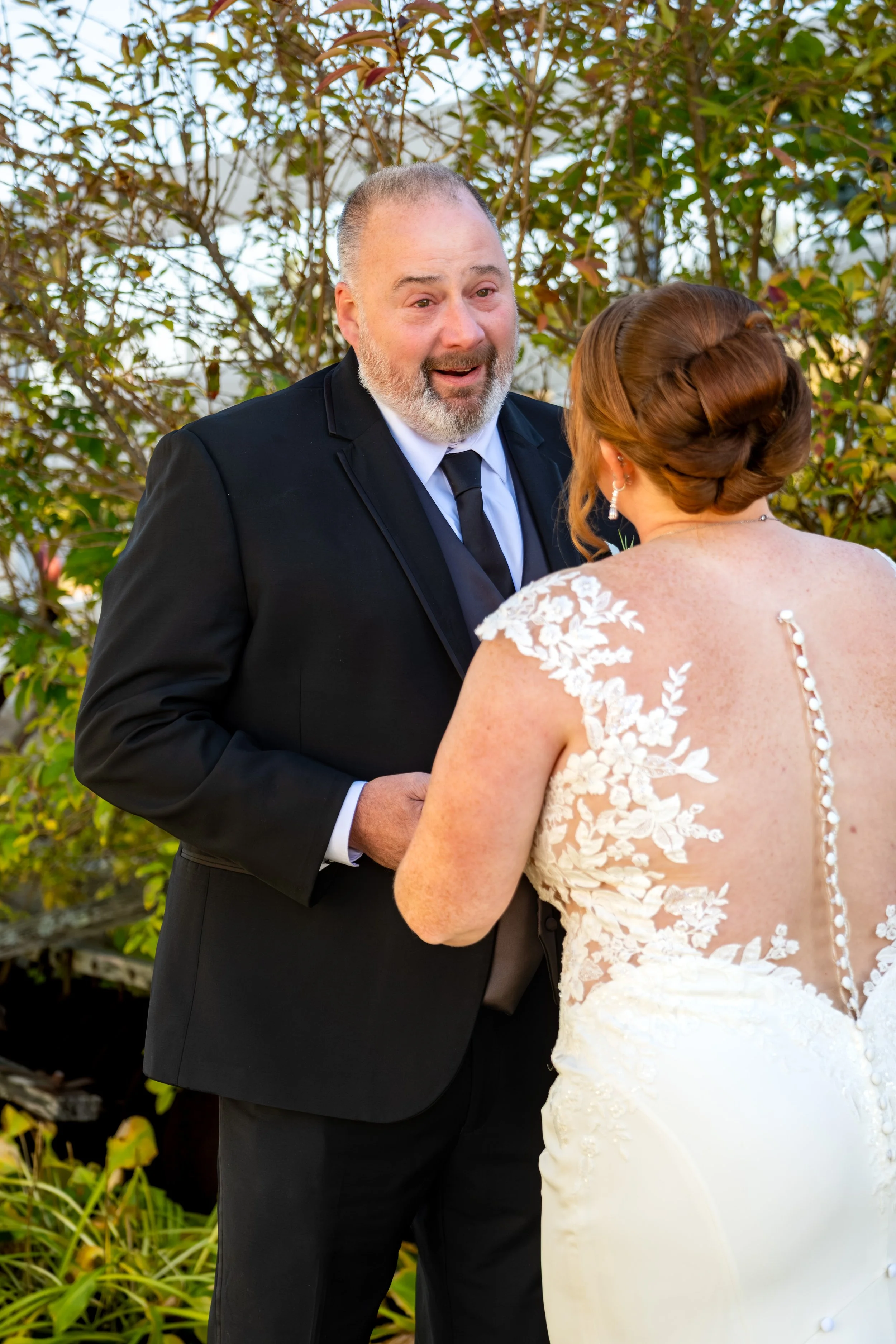 Erika's dad beaming as he sees her in her wedding dress at the Maine Wedding Barn and Event Center in Minot Maine fall wedding photography VMG Productions