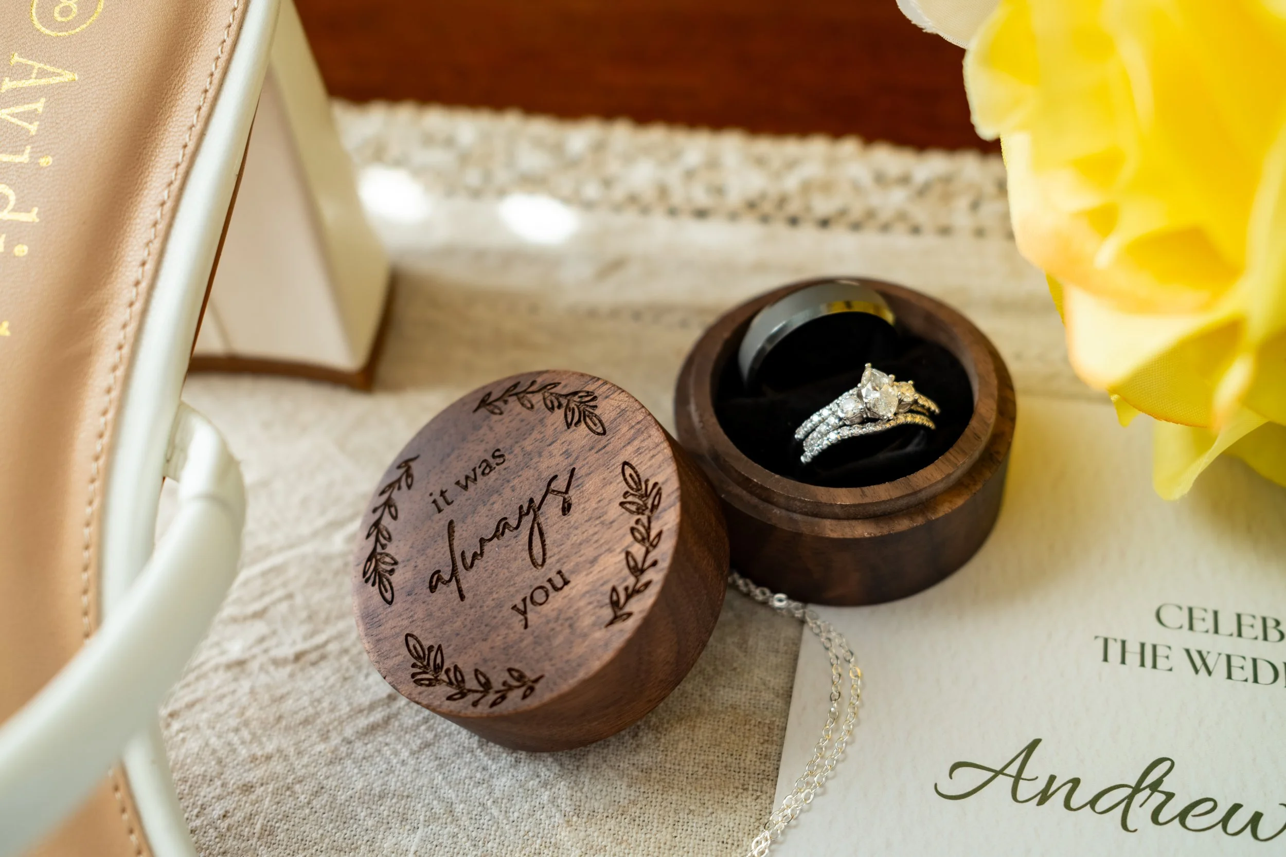 Wedding ring in an engraved wooden ring box beside yellow roses at the Maine Wedding Barn and Event Center in Minot Maine fall wedding photography VMG Productions