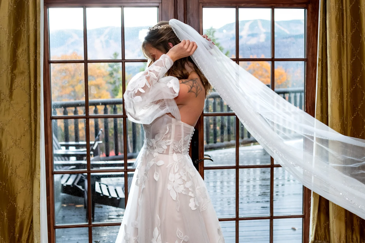 Bride pinning veil into hair during wedding morning preparation at SkiEsta Newry Maine fall wedding with mountain views