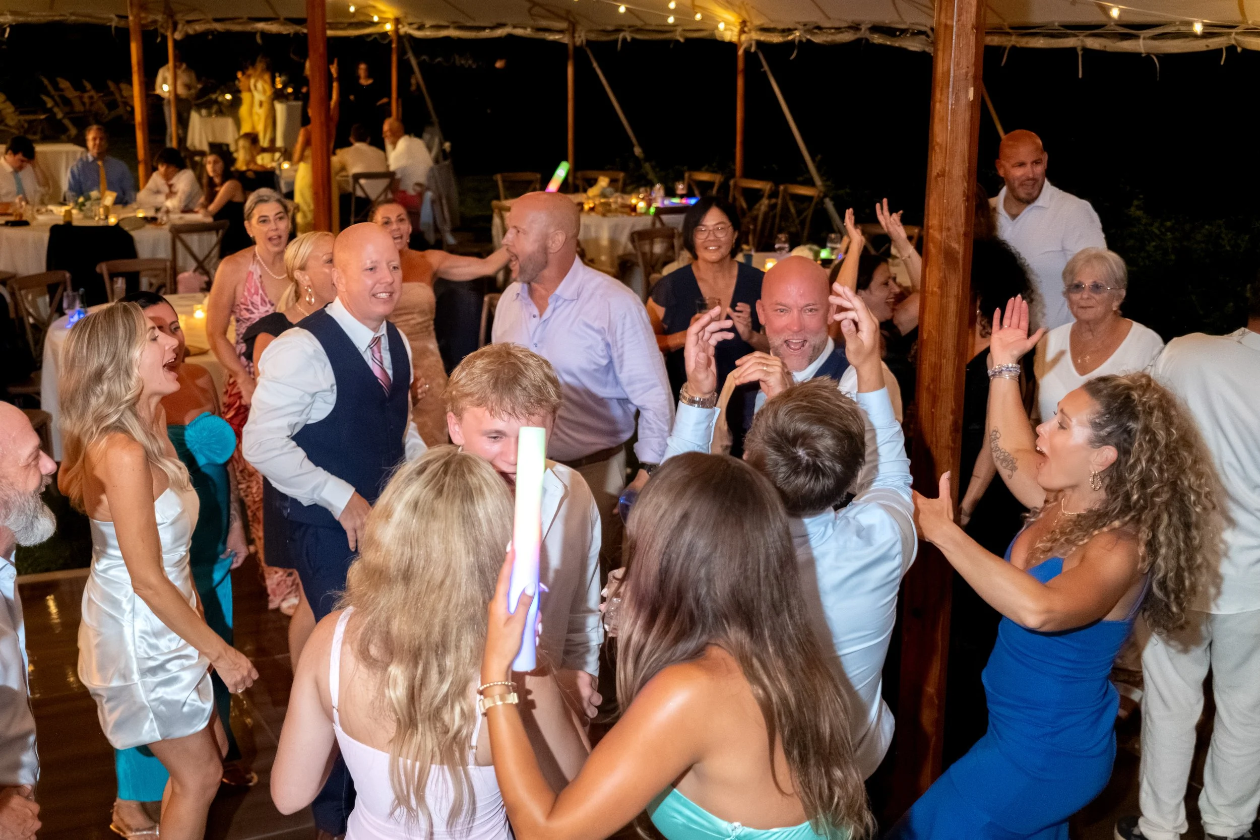 Packed dance floor under the string lights late into the night at Ashley and Marc Draper's reception at The Breakwater Inn in Kennebunkport Maine summer wedding photography VMG Productions