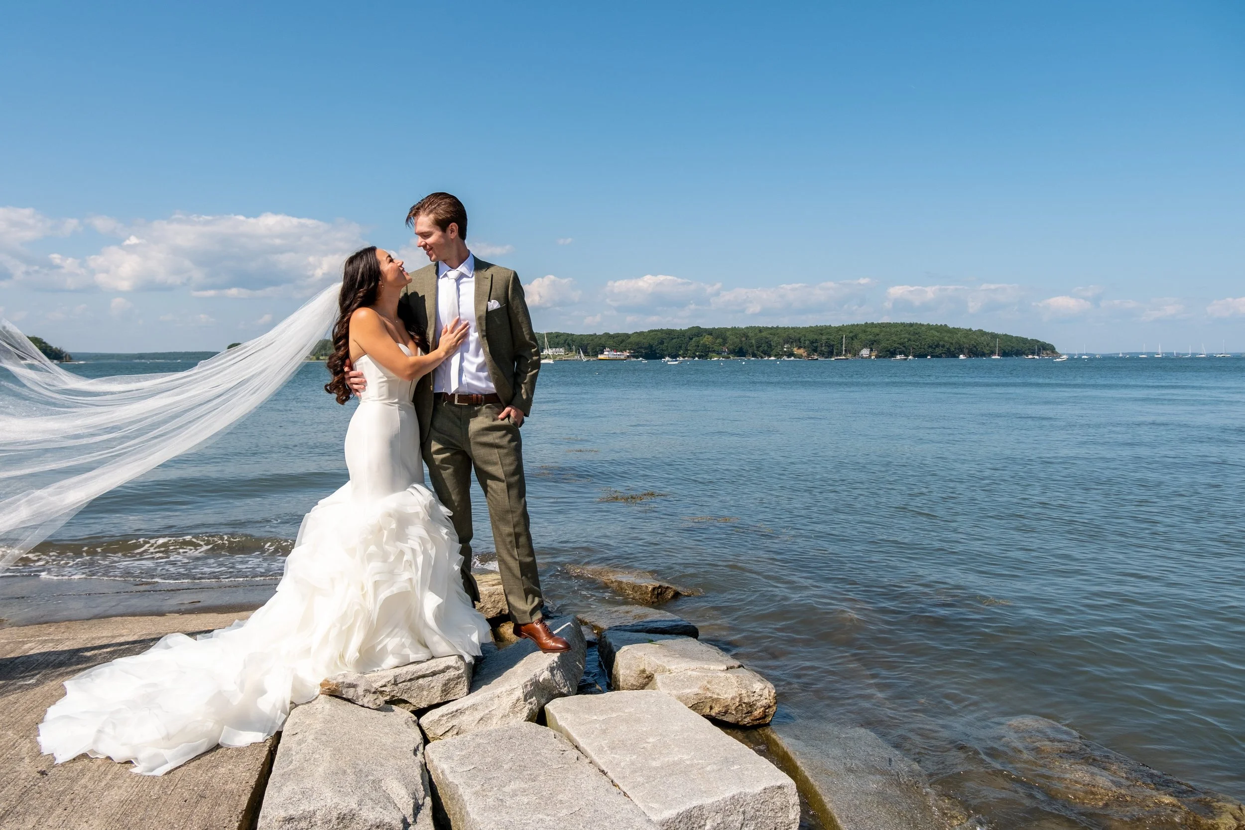 Couple portrait on Peaks Island with the coast behind them, Portland Maine wedding