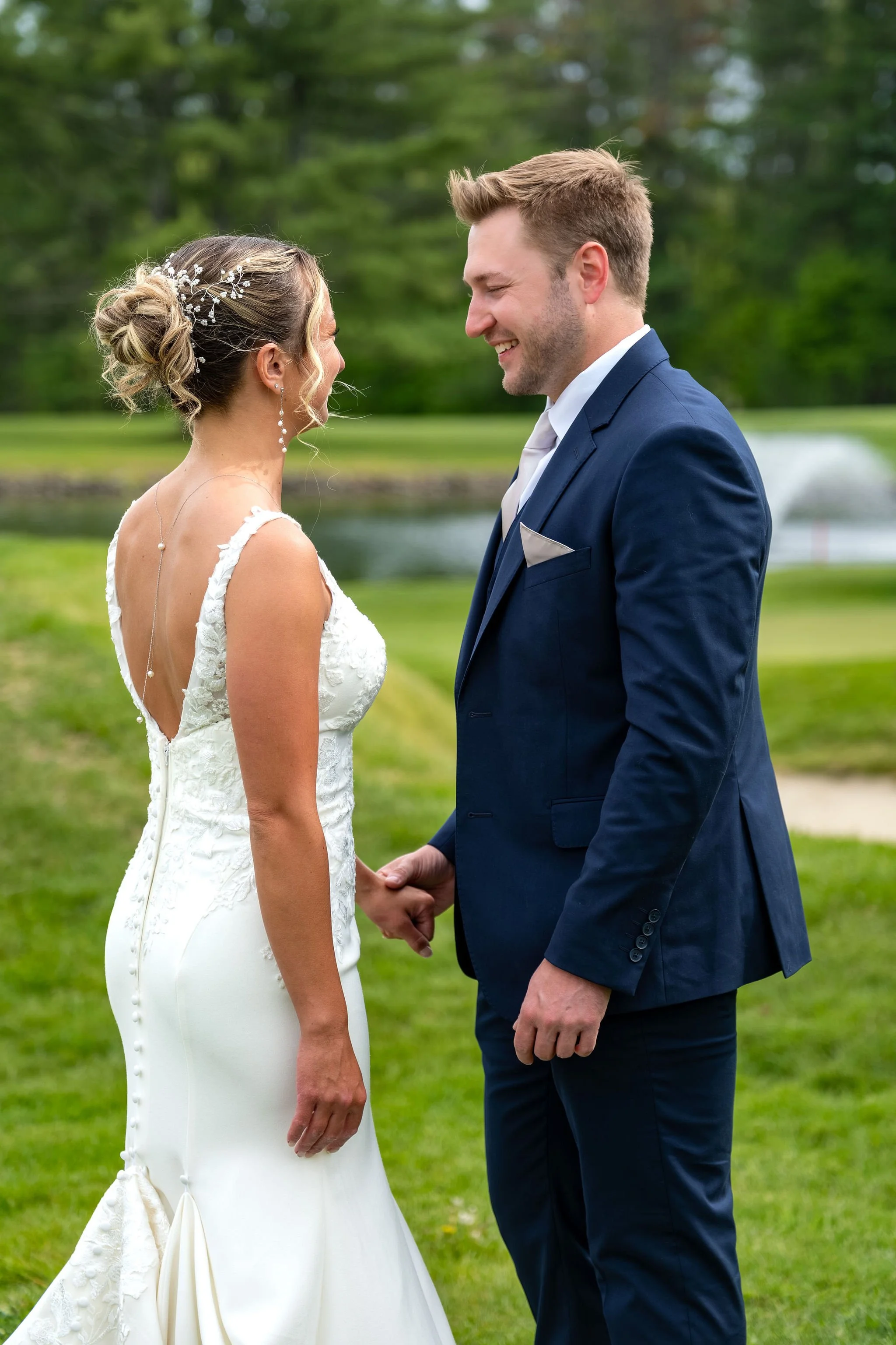Beth and Cameron bride and groom holding hands at their first look at Augusta Country Club Manchester Maine spring wedding photography VMG Productions