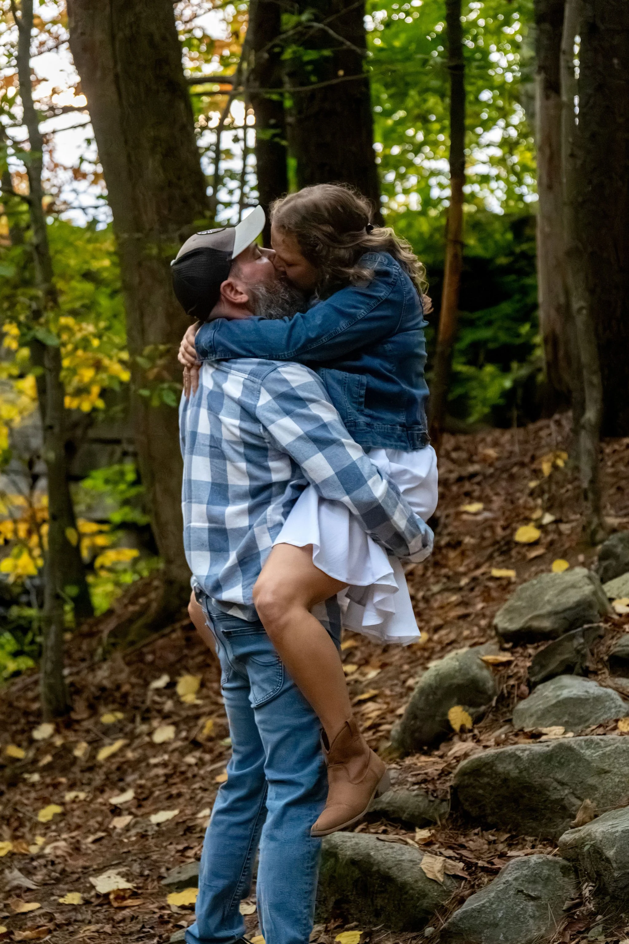 Dave holding Alison up in the air for a kiss on the stone stairs at Vaughan Woods in Hallowell Maine fall engagement photography VMG Productions