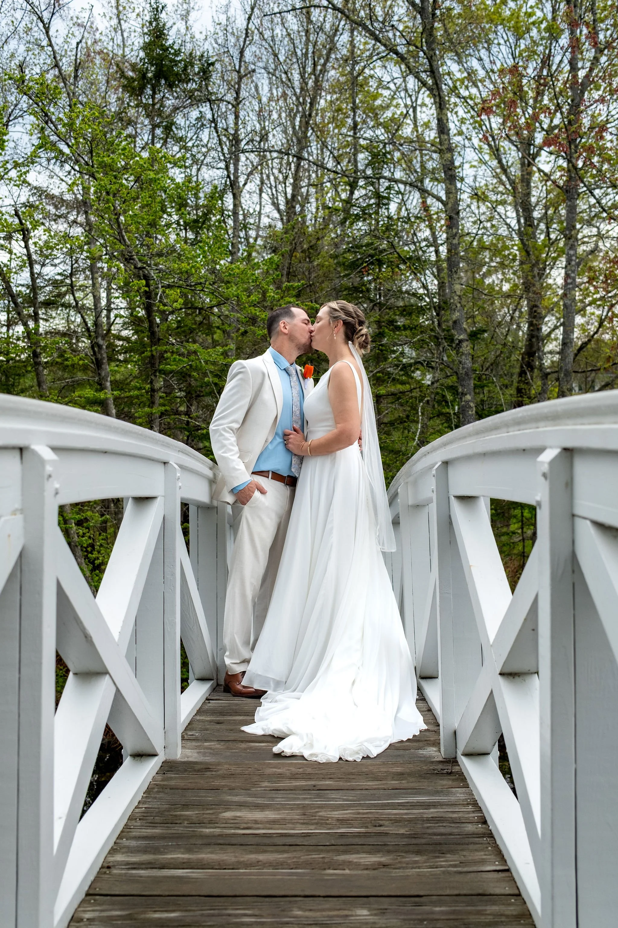 Alli and Adam Baudoin kissing at the crest of the Somesville footbridge on Mount Desert Island Maine spring wedding photography VMG Productions