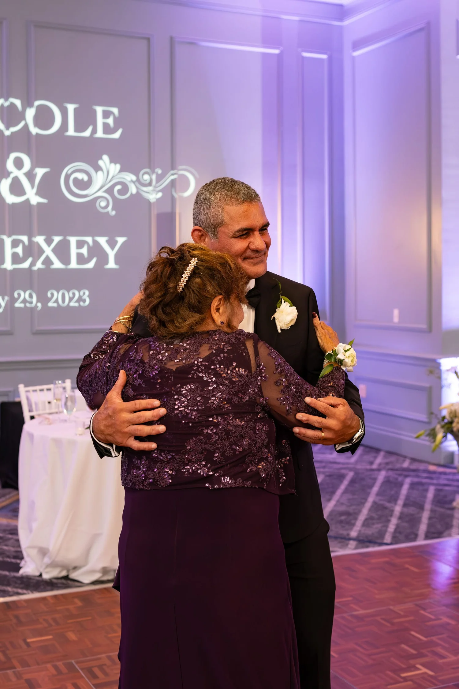 Alexey raising his fist in celebration beside the cake with Nicole at Portland Sheraton at Sable Oaks South Portland Maine summer wedding photography VMG Productions