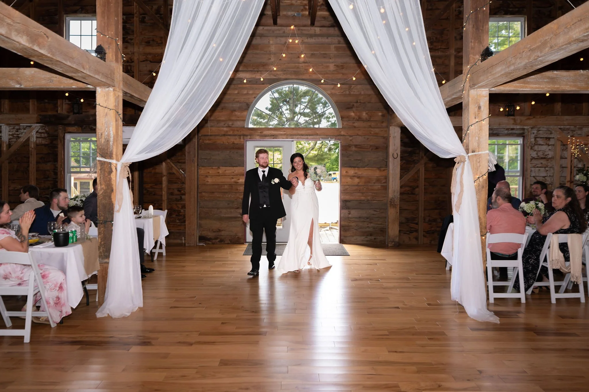 Alyssa and Colby making their grand entrance into the reception at the 1888 Barn Bethel Maine summer wedding photography VMG Productions
