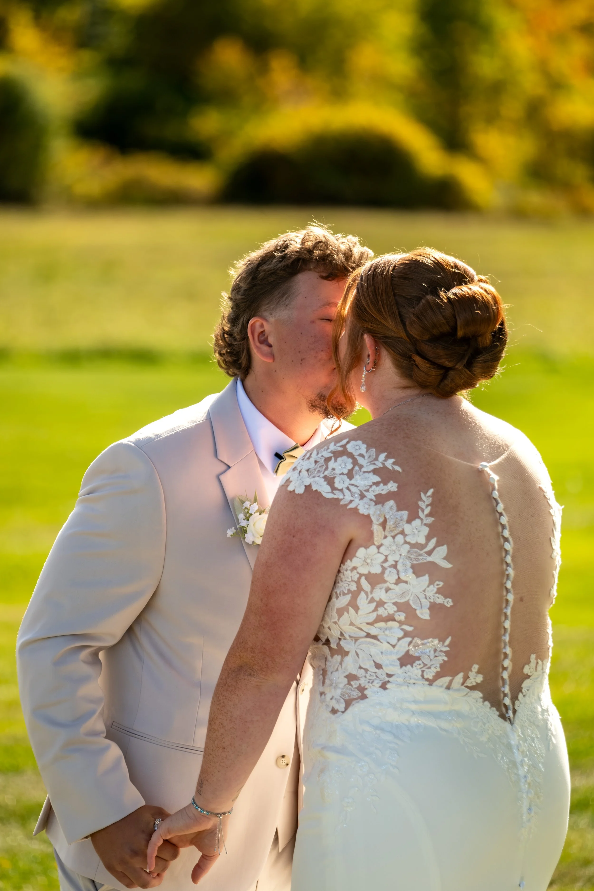Close portrait of Andrew and Erika sharing a kiss in the warm light at the Maine Wedding Barn and Event Center in Minot Maine fall wedding photography VMG Productions