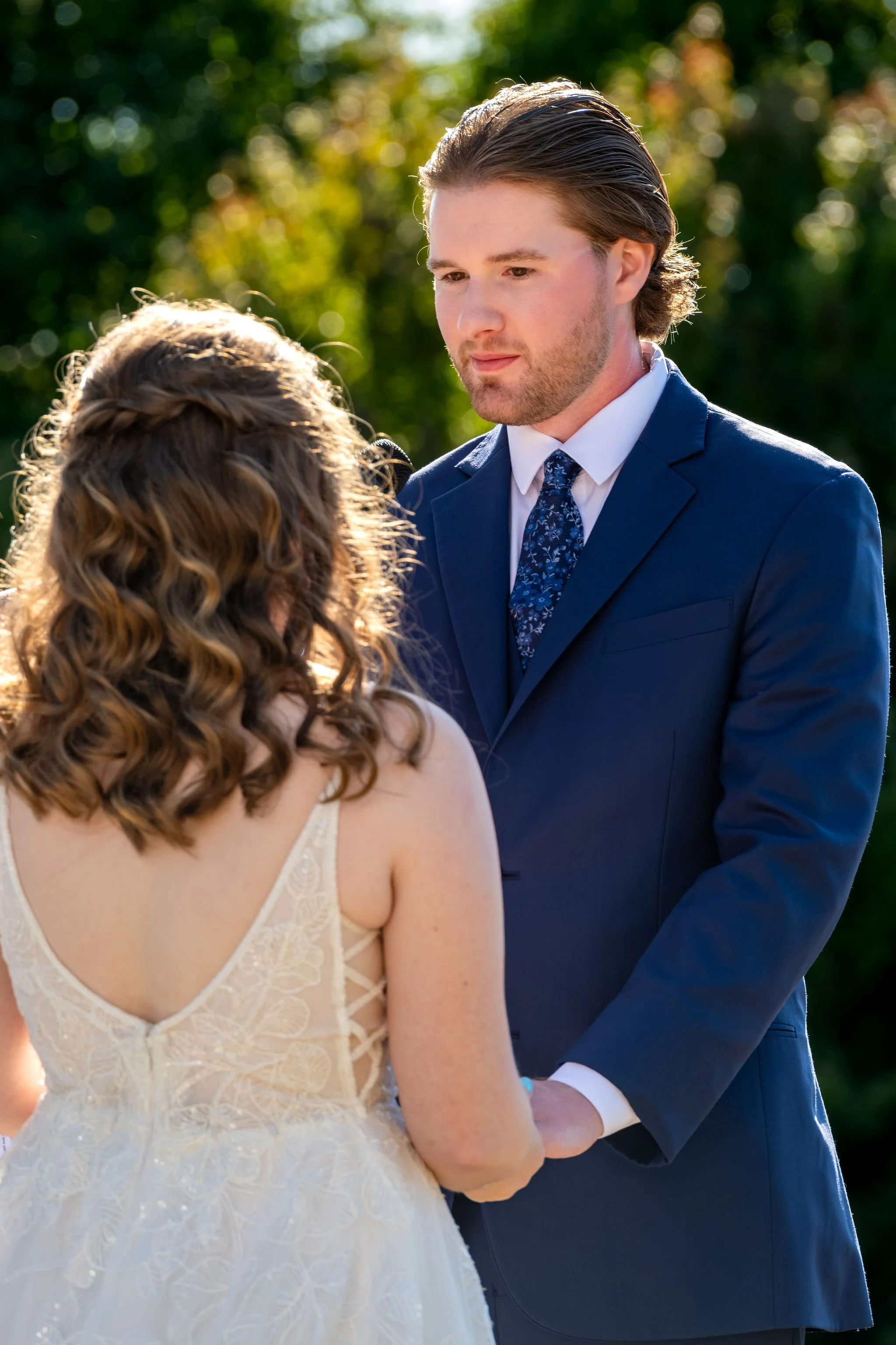 Zachary holding Hollie's hands and looking at her during the ceremony at the gazebo at The Lucerne Inn in Dedham Maine summer wedding photography VMG Productions
