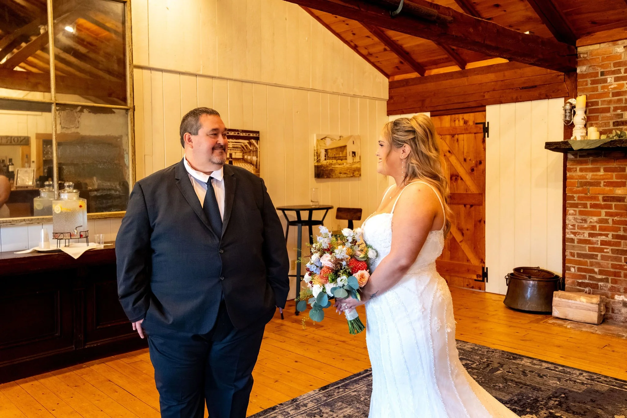 Ellie's dad seeing her in her wedding dress for the first time as she holds her bouquet at Boothbay Playhouse in Boothbay Maine fall wedding photography VMG Productions