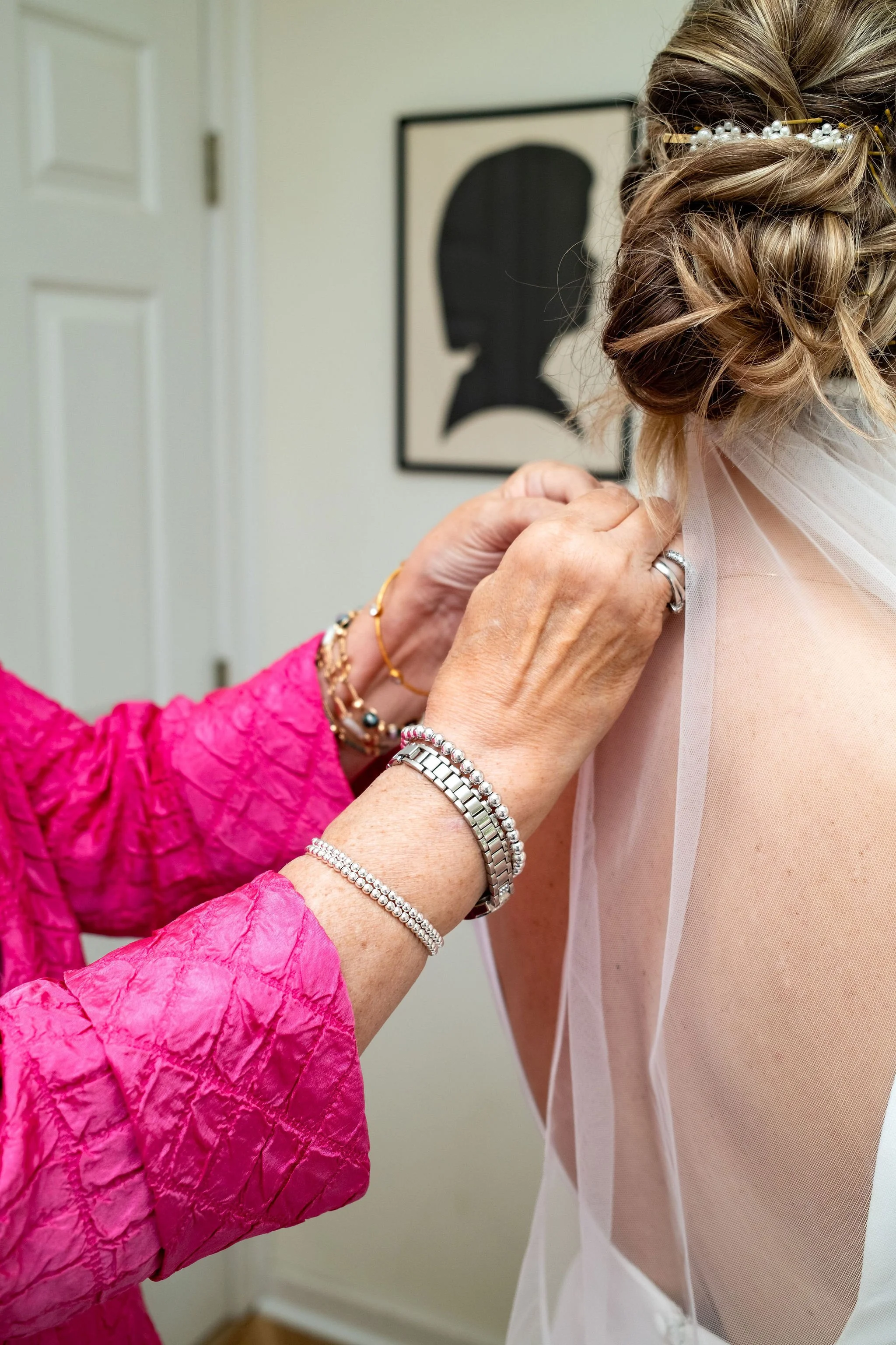 Mother of the bride helping Alli Baudoin with her jewelry while getting ready at a private residence in Mount Desert Maine spring wedding photography VMG Productions