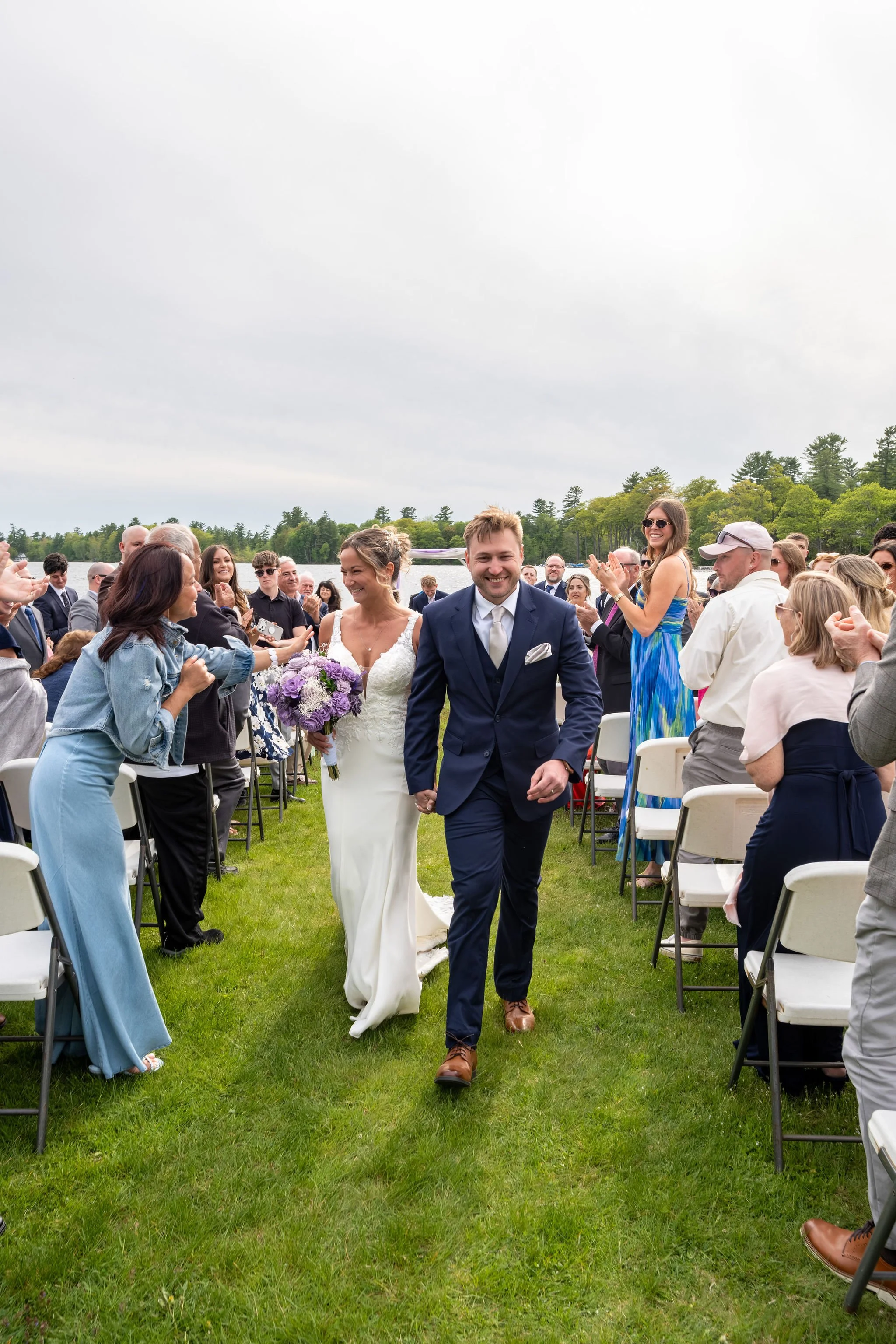Beth and Cameron bride and groom kissing beside the lake after the ceremony at Augusta Country Club Manchester Maine spring wedding photography VMG Productions