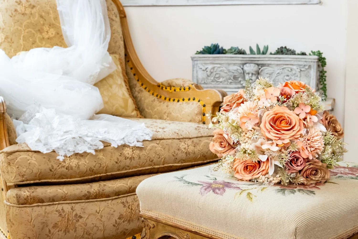 Peach rose wedding bouquet resting on vintage chair with bridal gown at Penobscot Bay Estate Winterport Maine