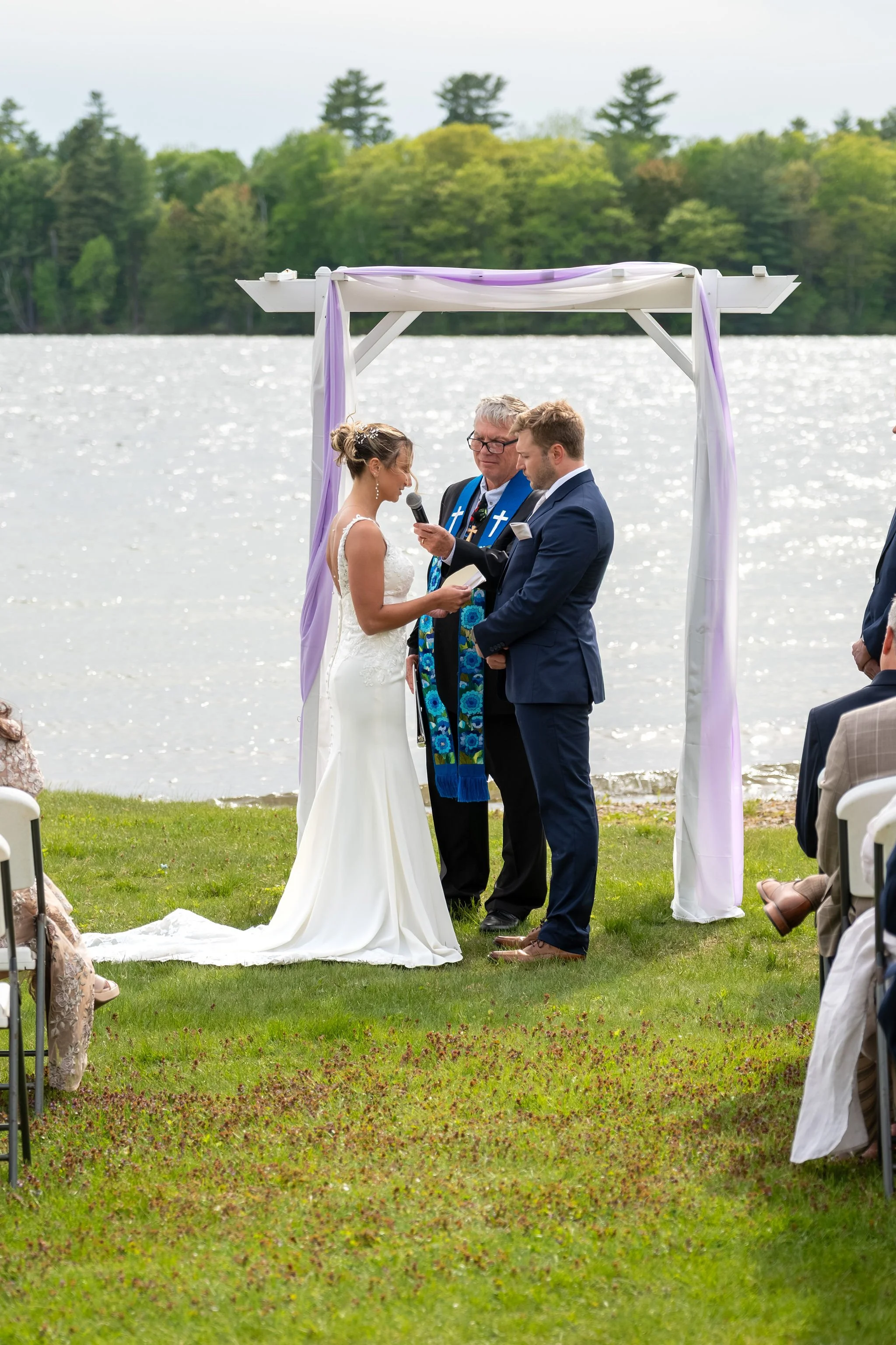Beth and Cameron bride and groom exchanging vows at the ceremony arbor at Augusta Country Club Manchester Maine spring wedding photography VMG Productions