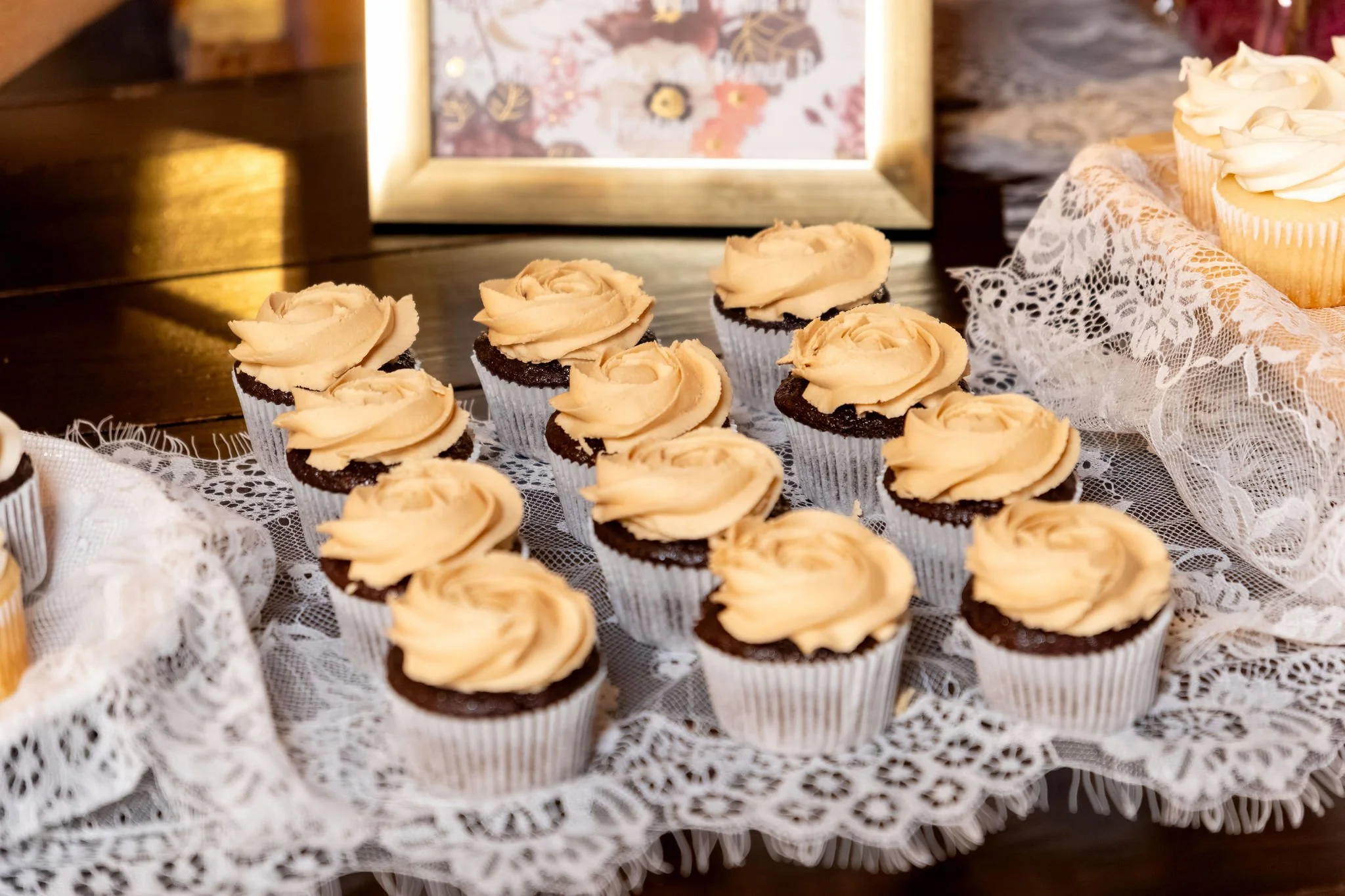 Cupcakes with swirled caramel frosting displayed on a lace runner at Boothbay Playhouse in Boothbay Maine fall wedding photography VMG Productions