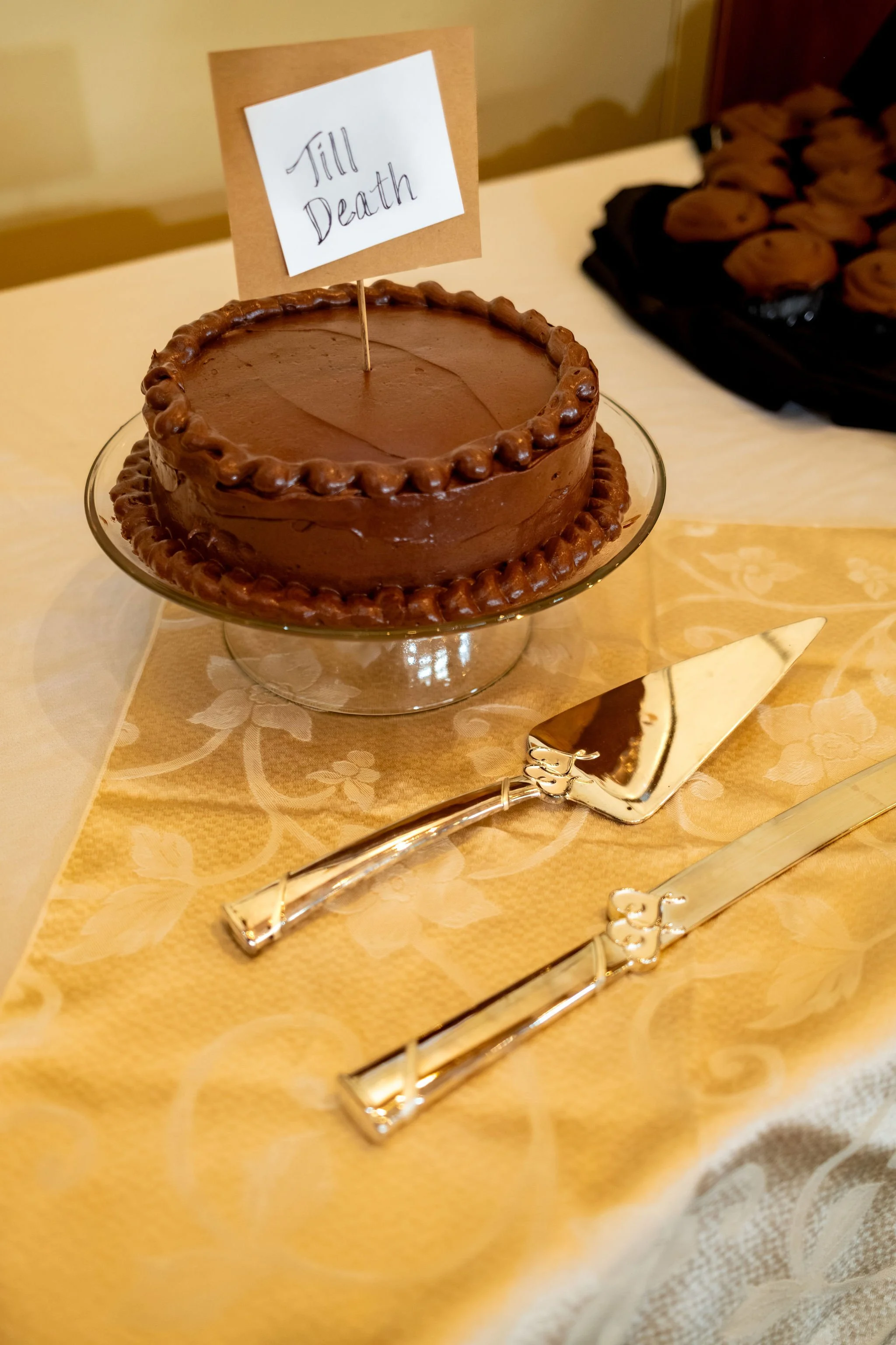 Chocolate wedding cake with a Till Death topper and silver cake knife at Cassidy and Chase Begin's reception at Maple Hill Farm Inn and Conference Center in Hallowell Maine summer wedding photography VMG Productions
