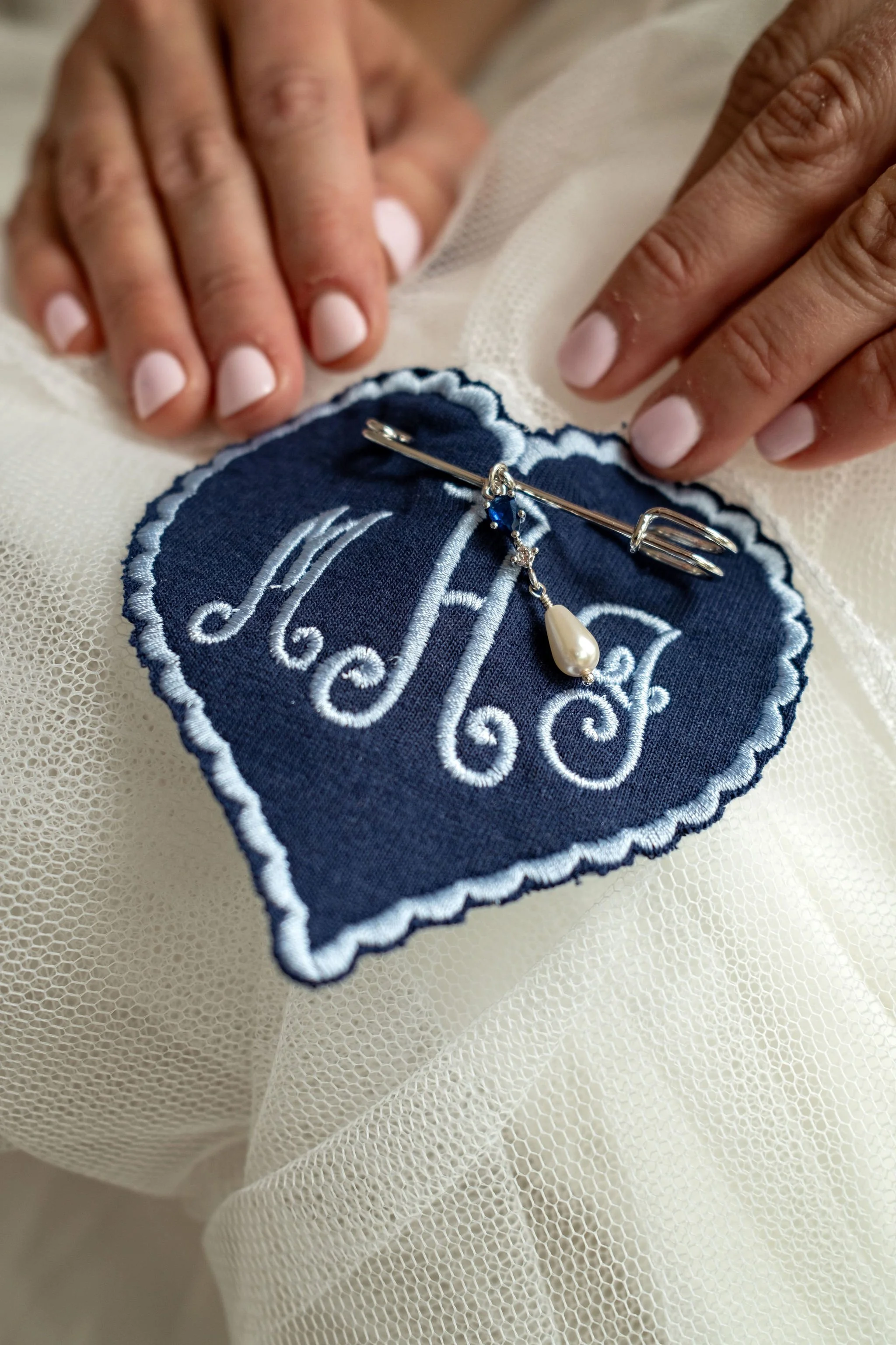 Embroidered navy heart keepsake pinned as the something blue in Alli Baudoin's veil at a Mount Desert Maine spring wedding photography VMG Productions