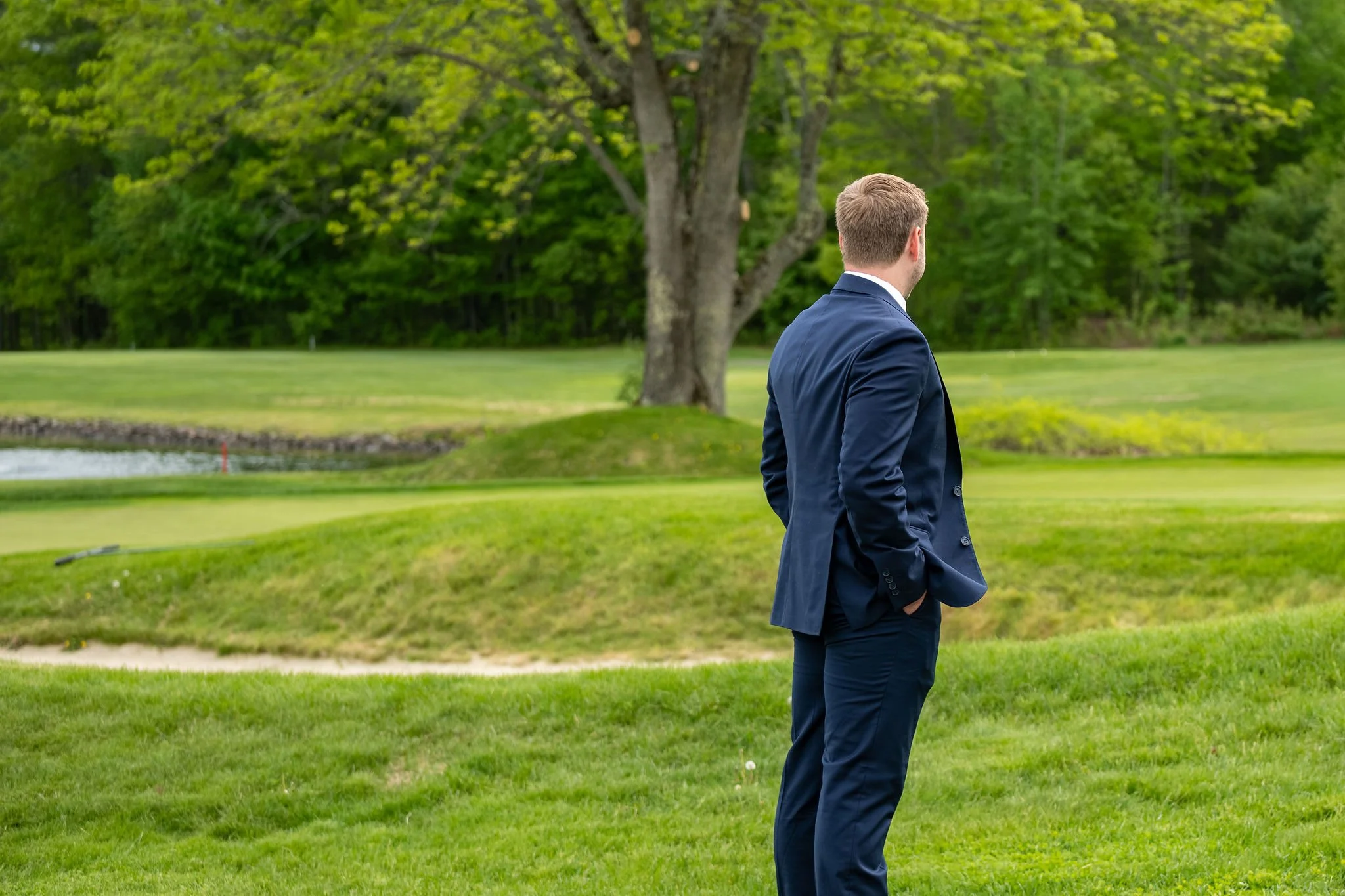 Beth and Cameron groom waiting on the golf course before the first look at Augusta Country Club Manchester Maine spring wedding photography VMG Productions