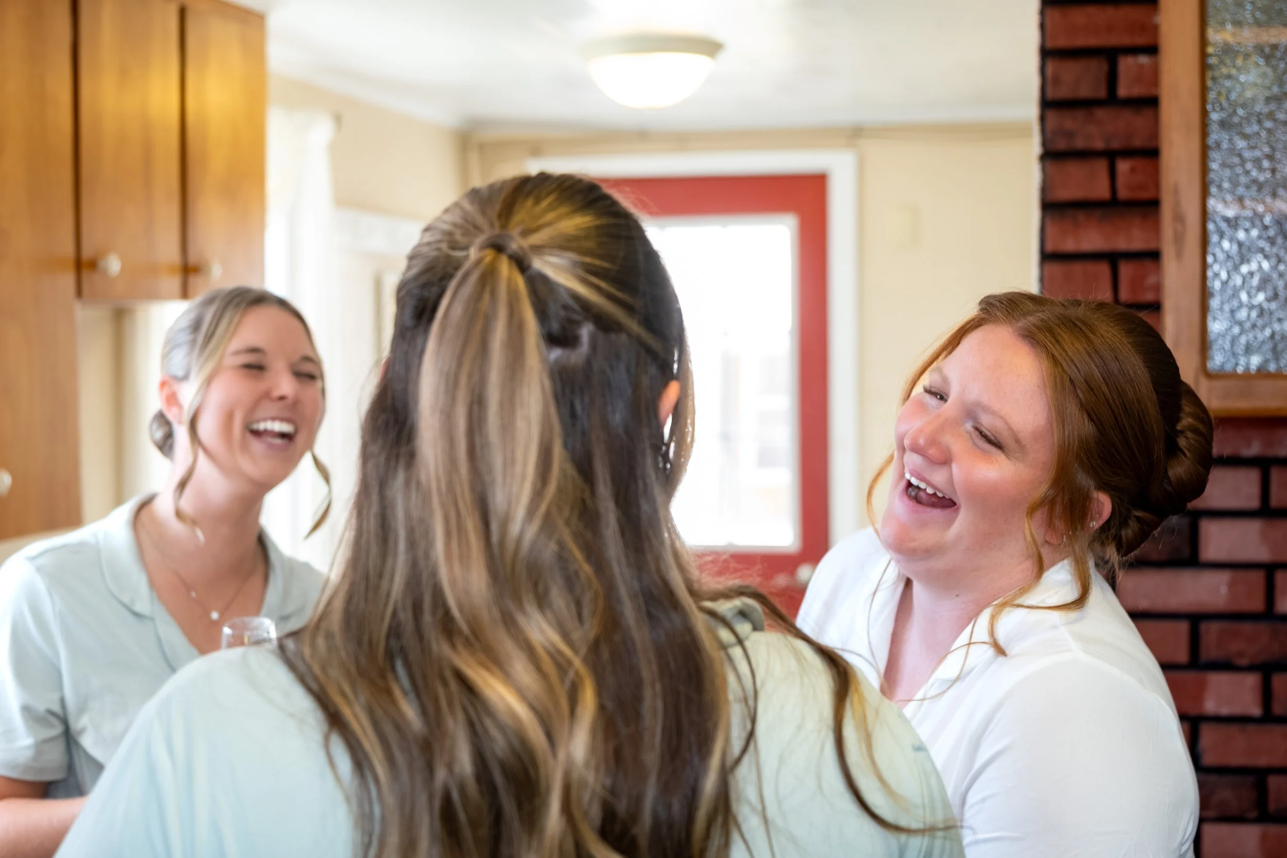 Bridesmaids laughing together in the farm house during hair and makeup at the Maine Wedding Barn and Event Center in Minot Maine fall wedding photography VMG Productions