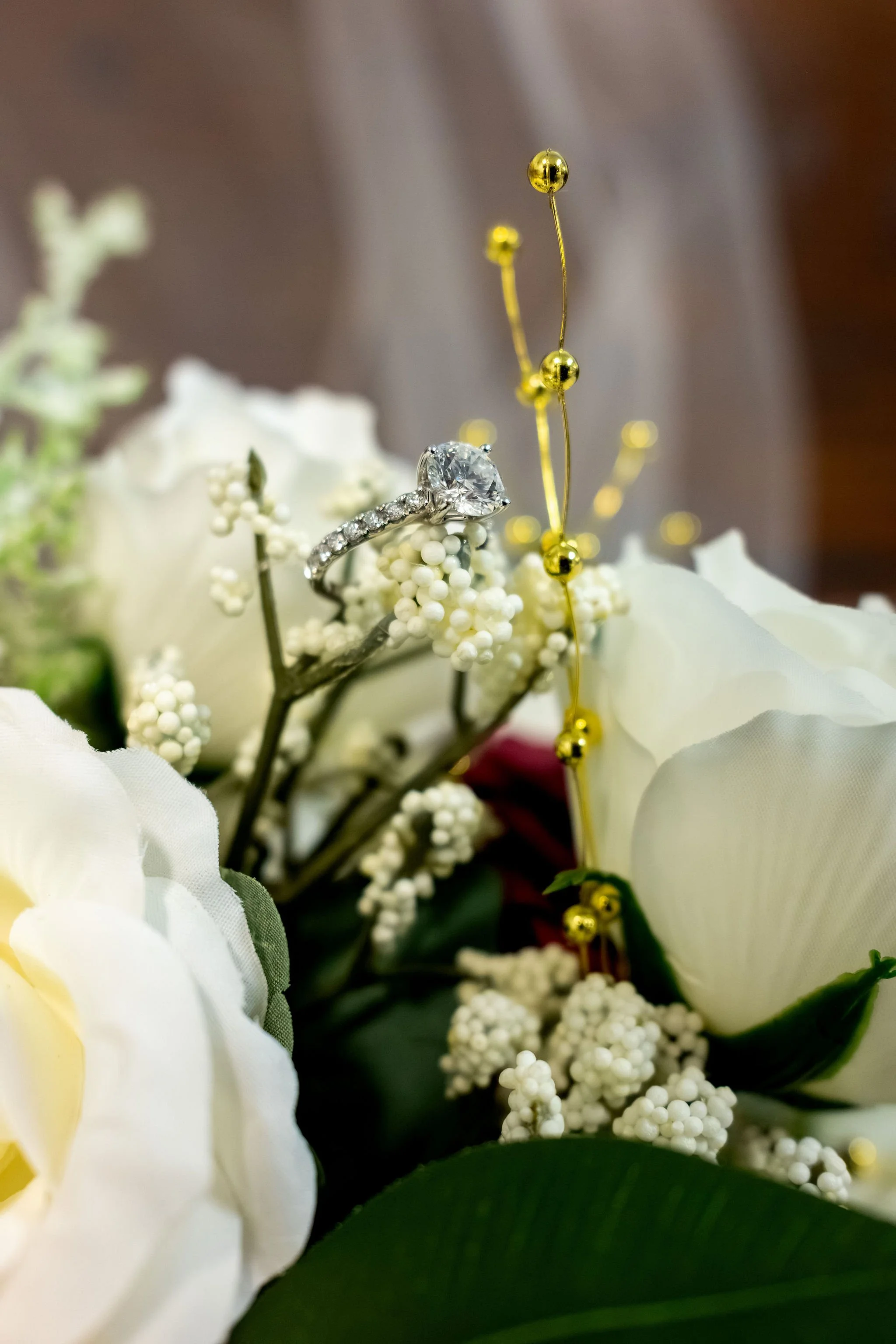 Jeremiah and Vienna vertical ring composition emphasizing floral textures and sparkle at Holy Trinity Greek Orthodox Church Portland Maine spring wedding photography VMG Productions