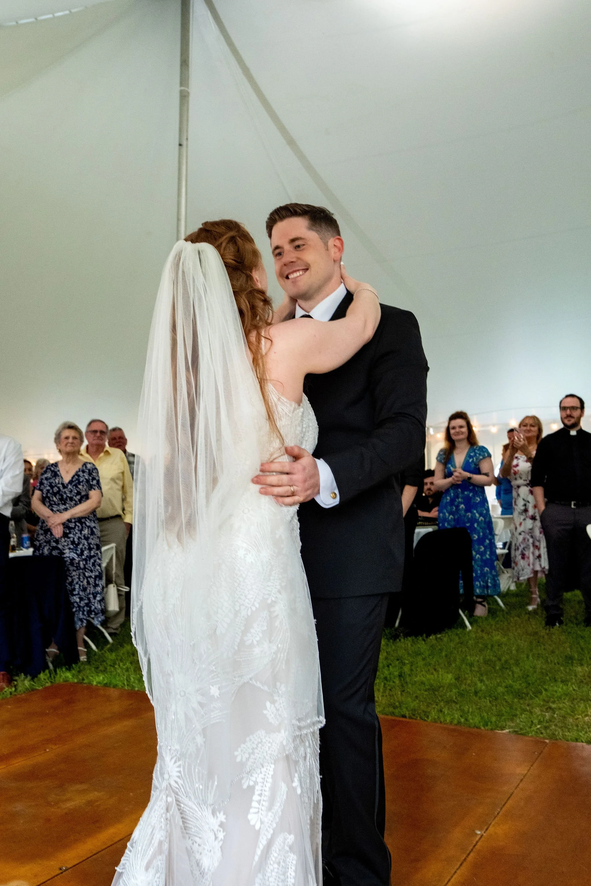 Kayla and Ethan DeAngelis first dance inside the reception tent with guests watching at their Sanbornton New Hampshire wedding photography VMG Productions