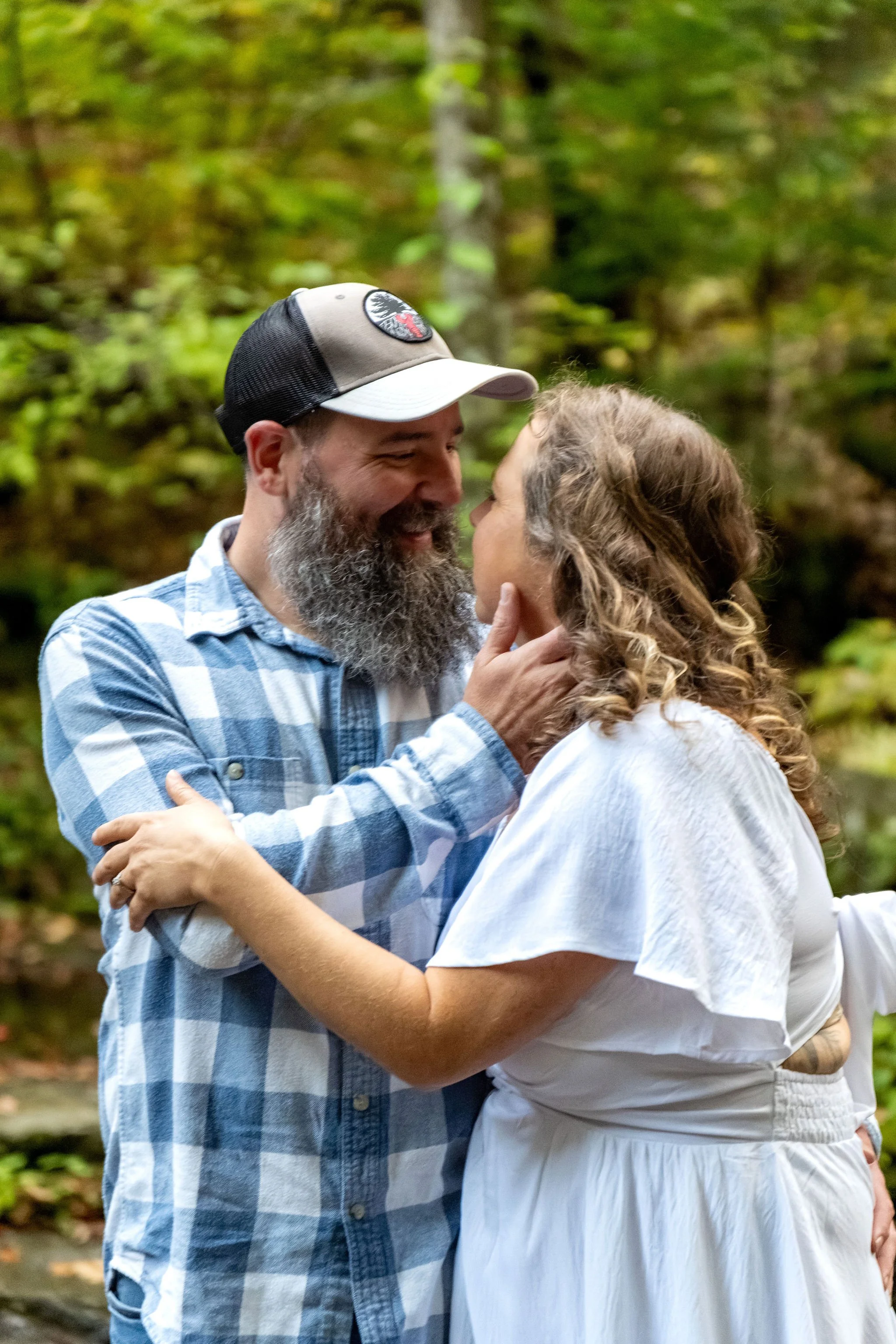 Alison and Dave nose to nose with the fall woods soft behind them at Vaughan Woods in Hallowell Maine fall engagement photography VMG Productions