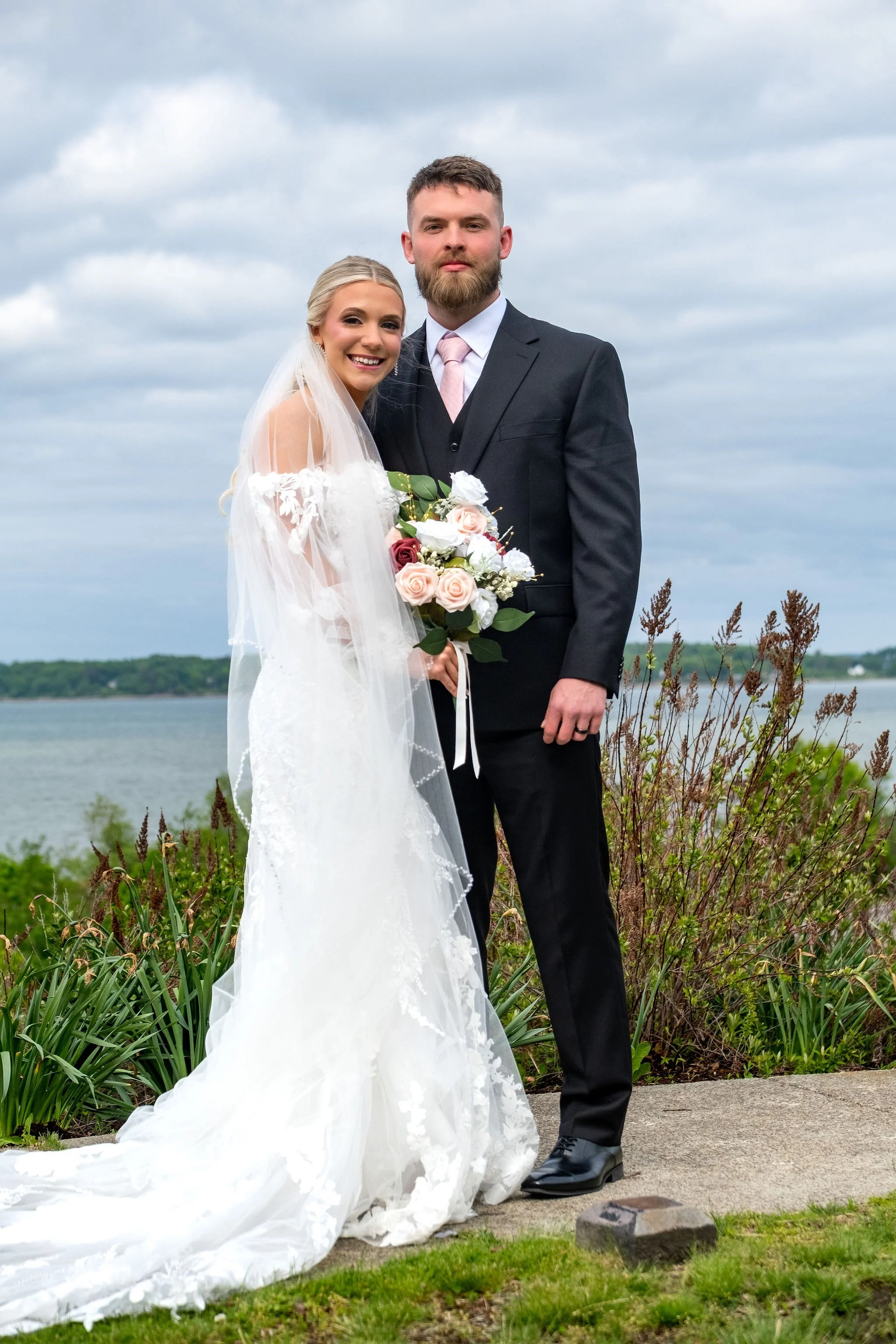 Jeremiah and Vienna full-length portrait showcasing wedding attire against a coastal Maine backdrop at Eastern Promenade Portland Maine spring wedding photography VMG Productions