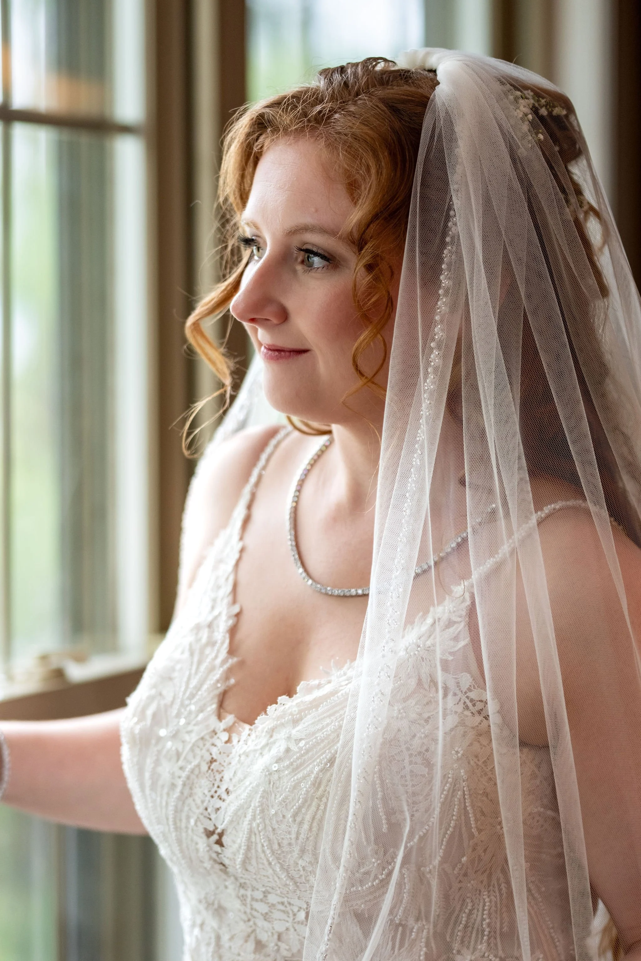 Kayla DeAngelis bridal portrait with veil at the window before her ceremony in Belmont New Hampshire summer wedding photography VMG Productions