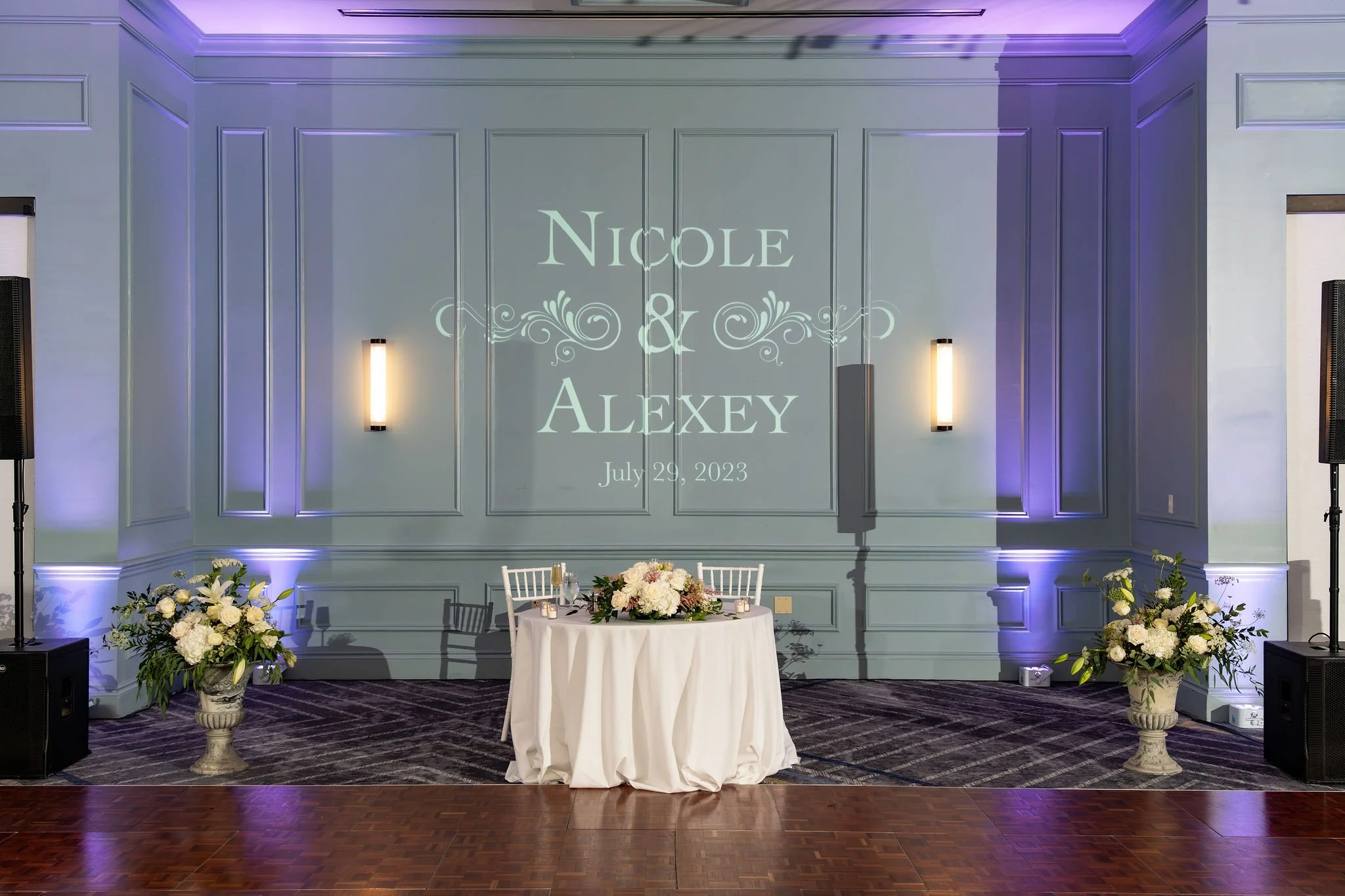 The sweetheart table beneath Nicole and Alexey's monogram in light at Portland Sheraton at Sable Oaks South Portland Maine summer wedding photography VMG Productions