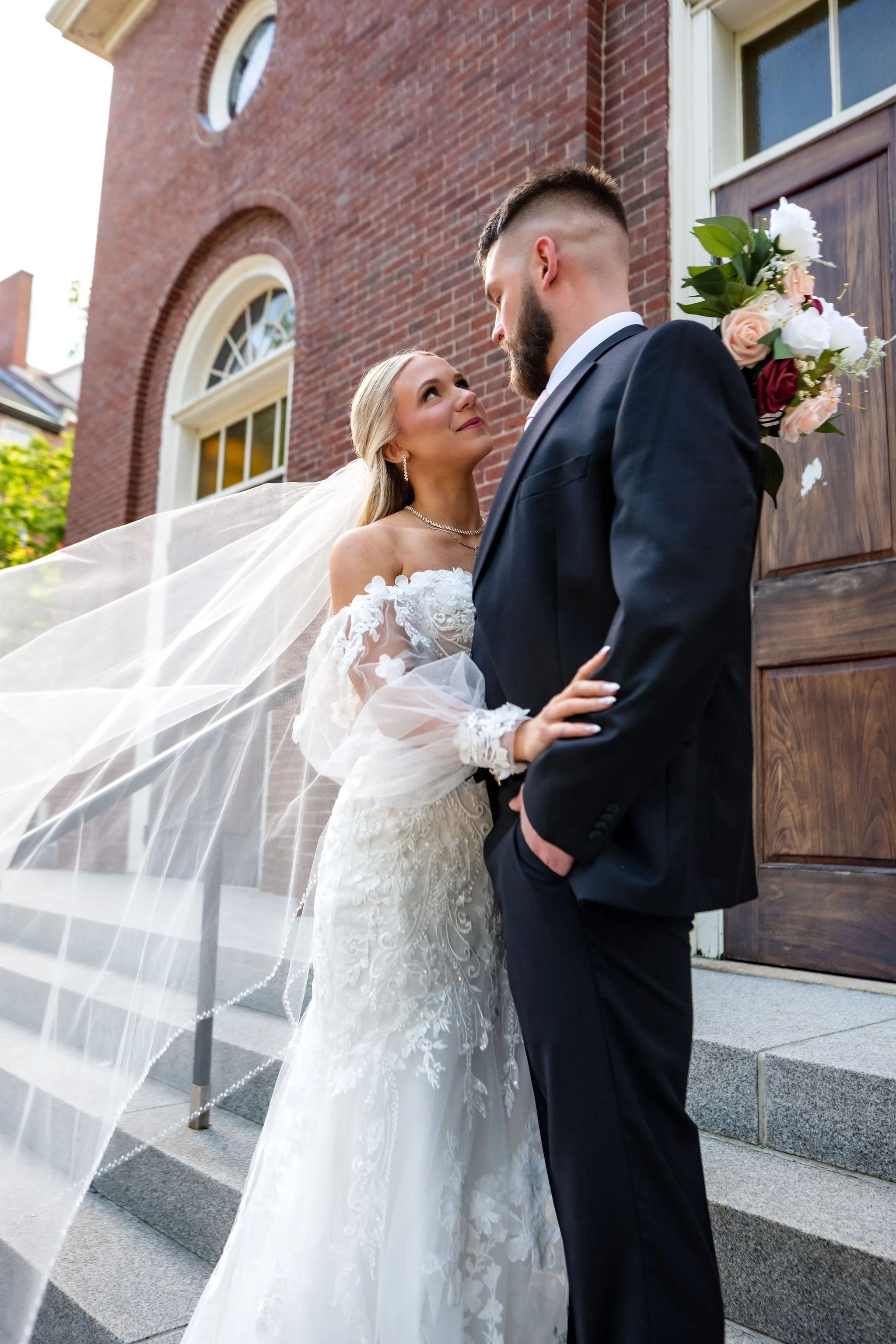 Jeremiah and Vienna elegant portrait featuring flowing veil illuminated by afternoon light at Holy Trinity Greek Orthodox Church Portland Maine spring wedding photography VMG Productions