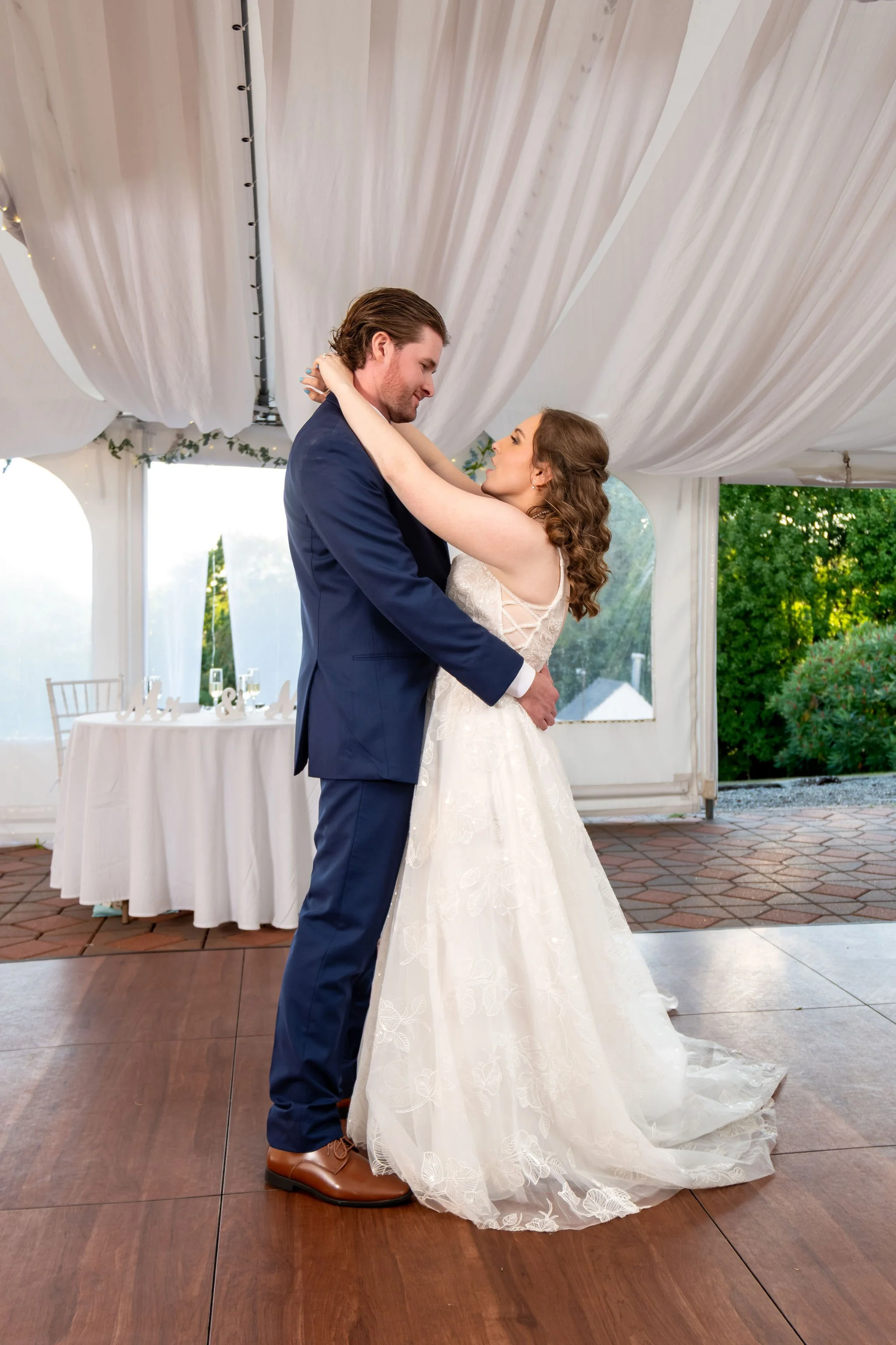 Zachary and Hollie's first dance under the white draped tent with the hills in the distance at The Lucerne Inn in Dedham Maine summer wedding photography VMG Productions