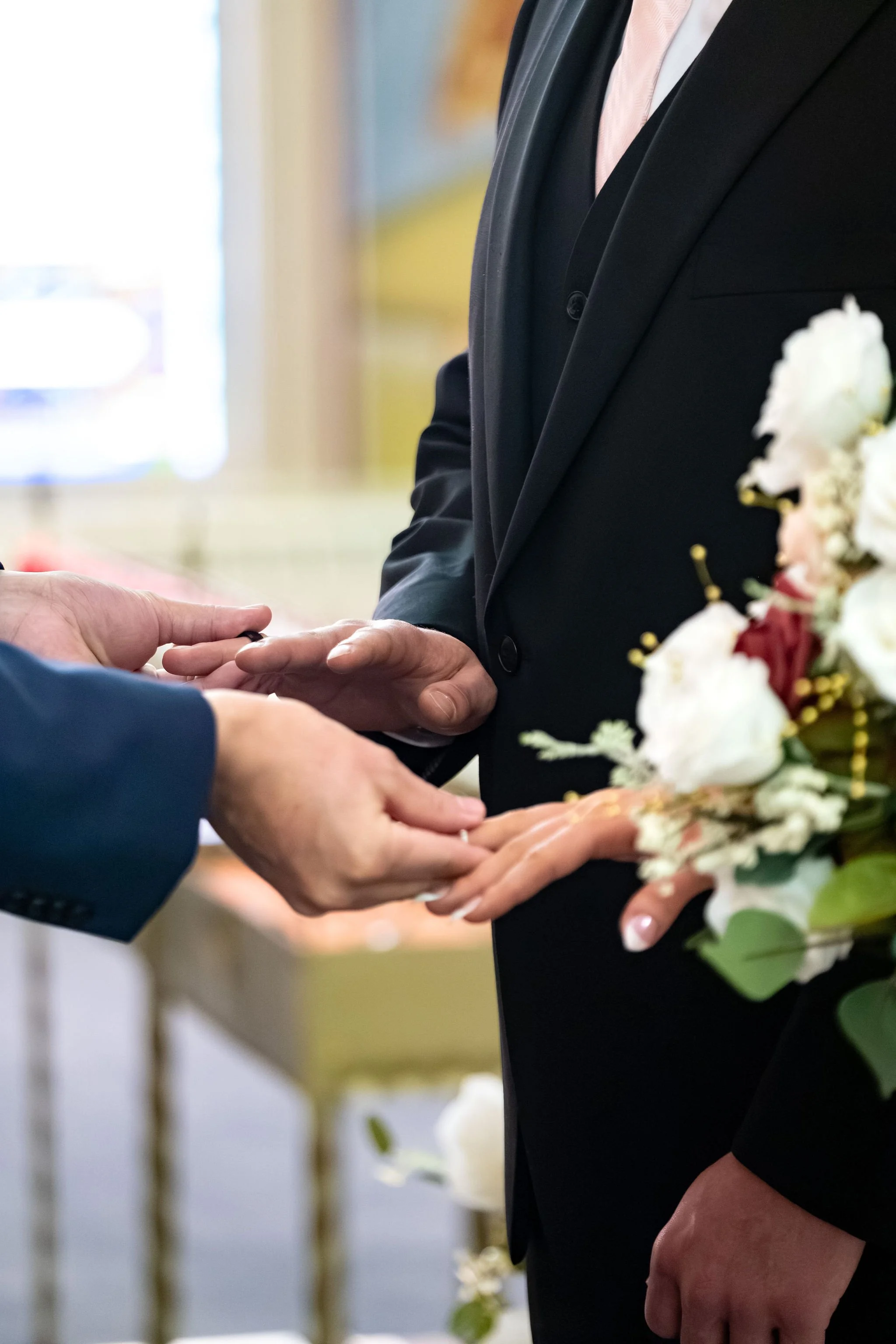 Jeremiah and Vienna close-up detail of rings being exchanged during the ceremony at Holy Trinity Greek Orthodox Church Portland Maine spring wedding photography VMG Productions