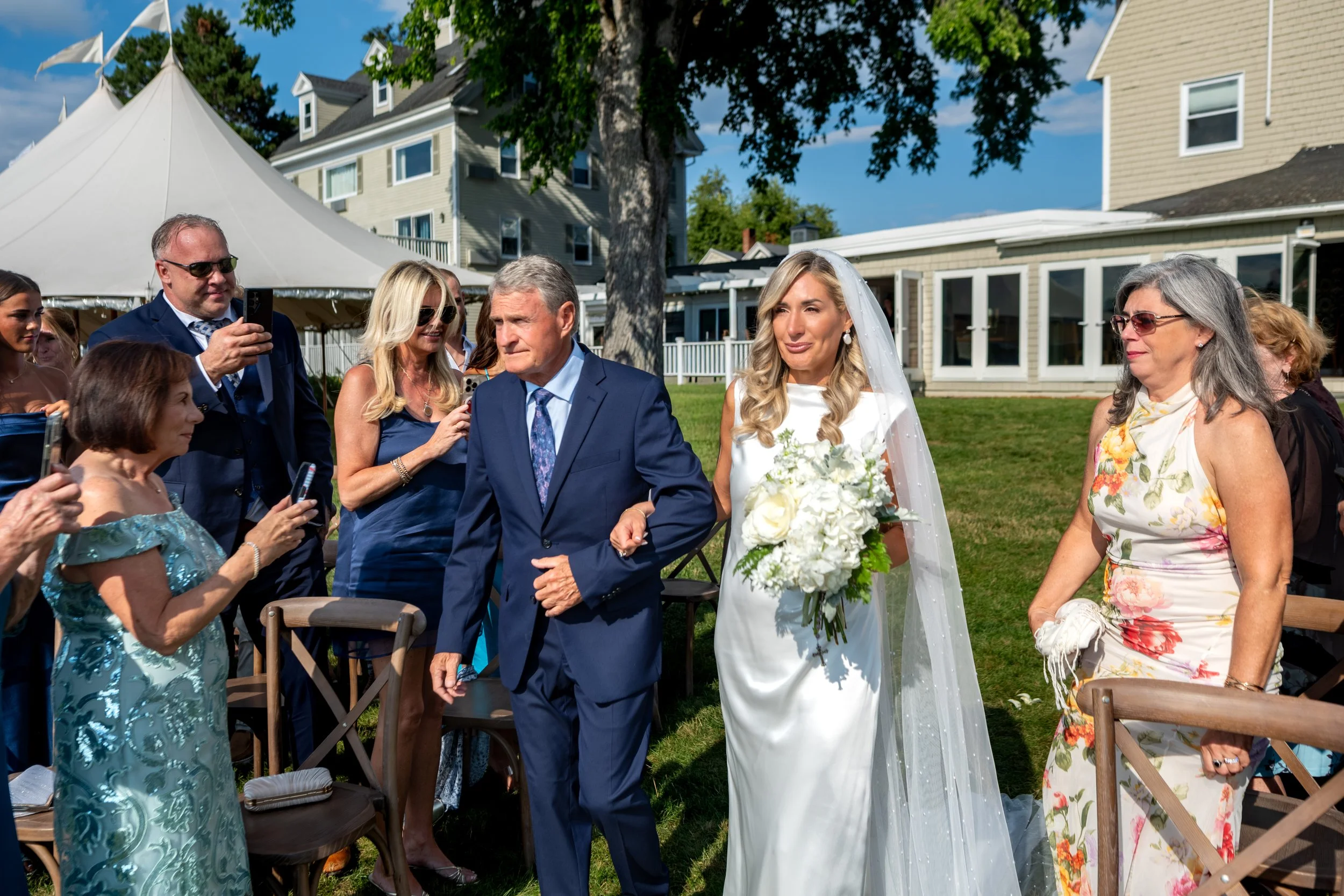 Ashley Draper walking down the aisle on her father Ernie's arm as Marc sees her for the first time at The Breakwater Inn in Kennebunkport Maine summer wedding photography VMG Productions
