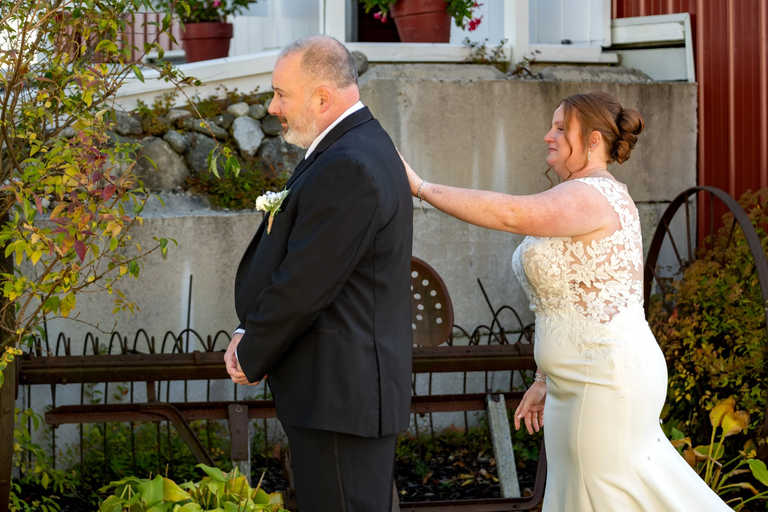 Erika's dad standing with his back to her as she waits behind him in her wedding dress at the Maine Wedding Barn and Event Center in Minot Maine fall wedding photography VMG Productions
