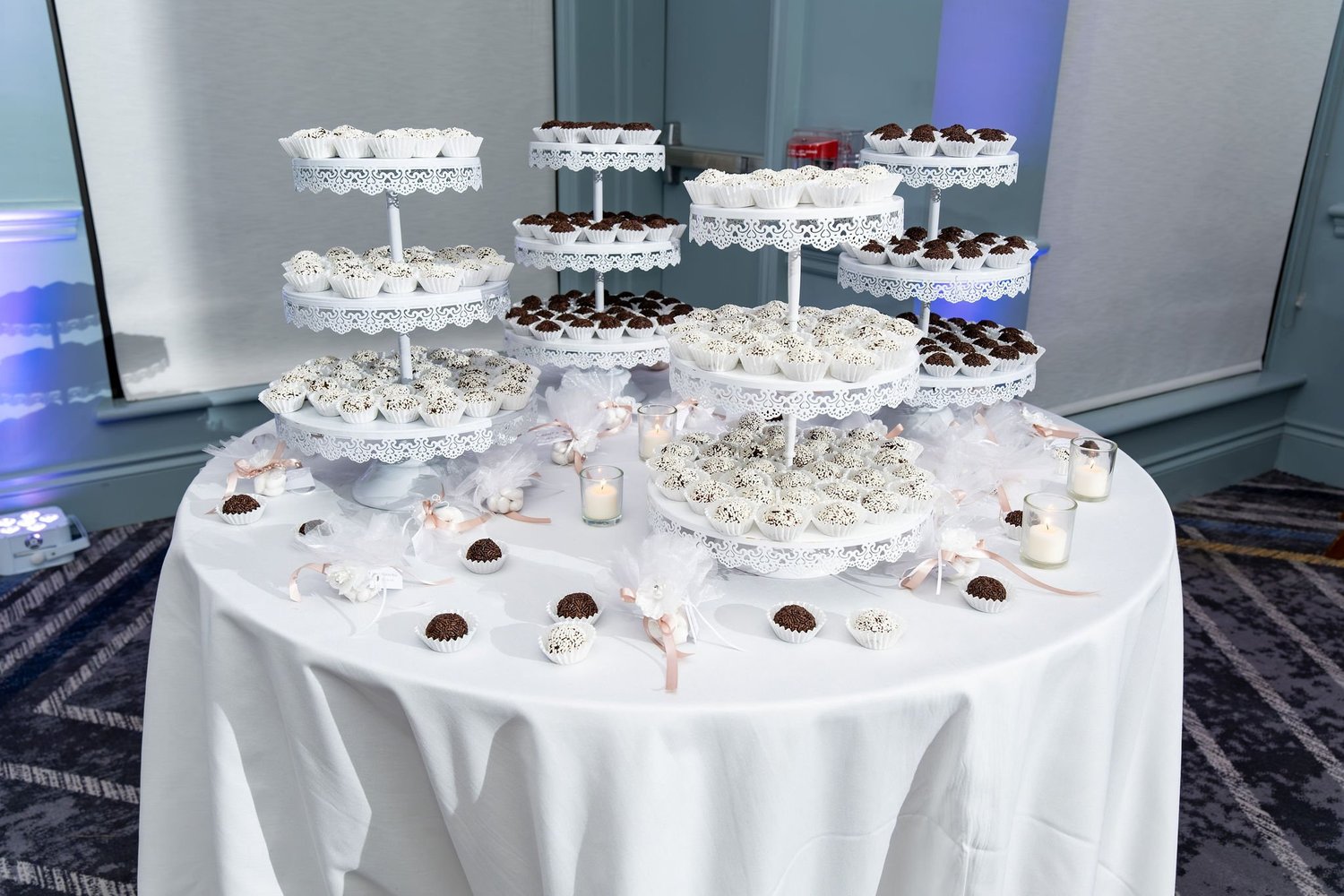 The dessert table with brigadeiros on lace stands and koufeta favors at Portland Sheraton at Sable Oaks South Portland Maine summer wedding photography VMG Productions