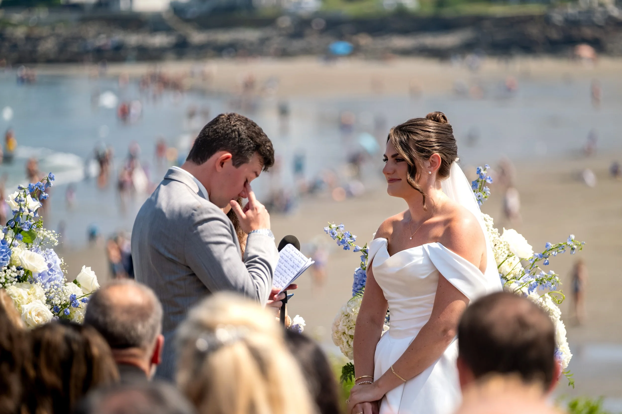 Anthony Pirolli wiping away tears while reading his vows to Caroline with the crowded York Beach soft behind them at Union Bluff Hotel wedding photography VMG Productions