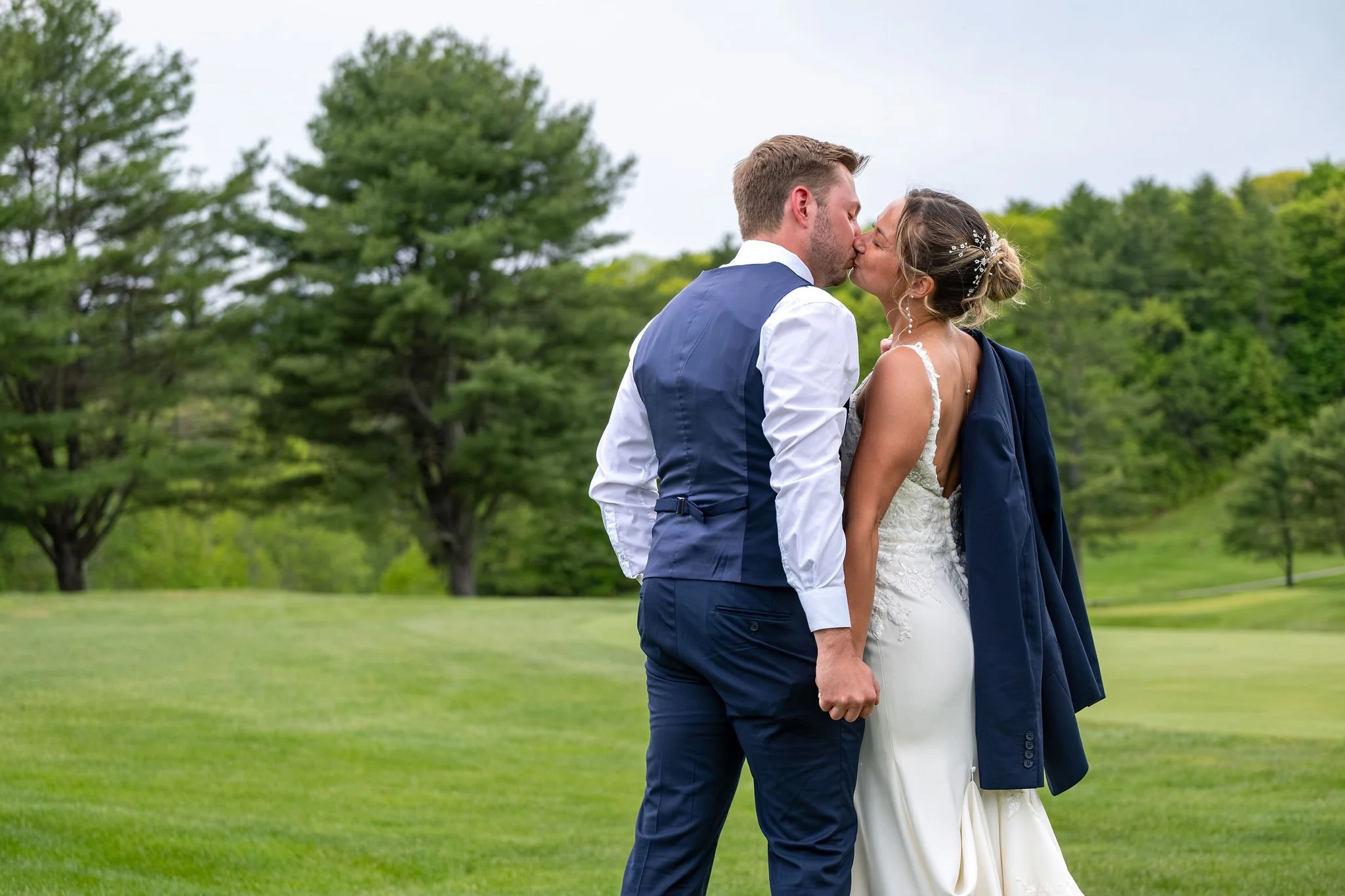 Beth and Cameron kissing on the golf course at Augusta Country Club Manchester Maine spring wedding photography VMG Productions