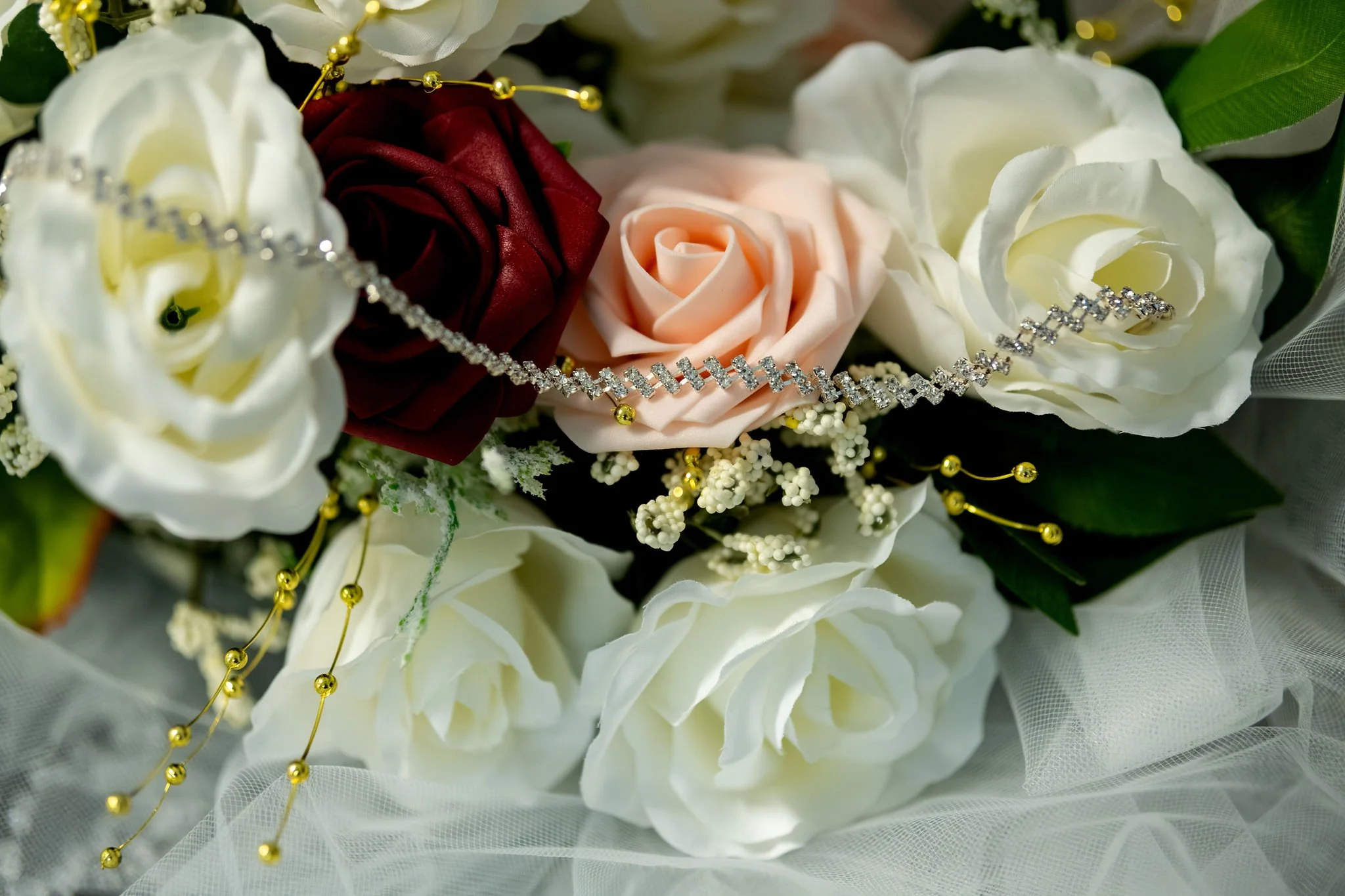Jeremiah and Vienna wedding necklace draped across bouquet featuring white, blush, and burgundy roses at Holy Trinity Greek Orthodox Church Portland Maine spring wedding photography VMG Productions
