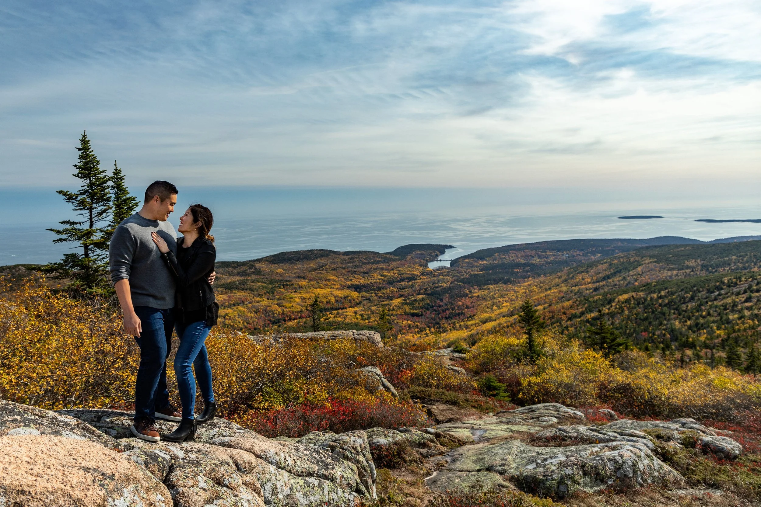 Agnes and Peter standing on Cadillac Mountain summit fall foliage panorama Acadia National Park engagement VMG Productions