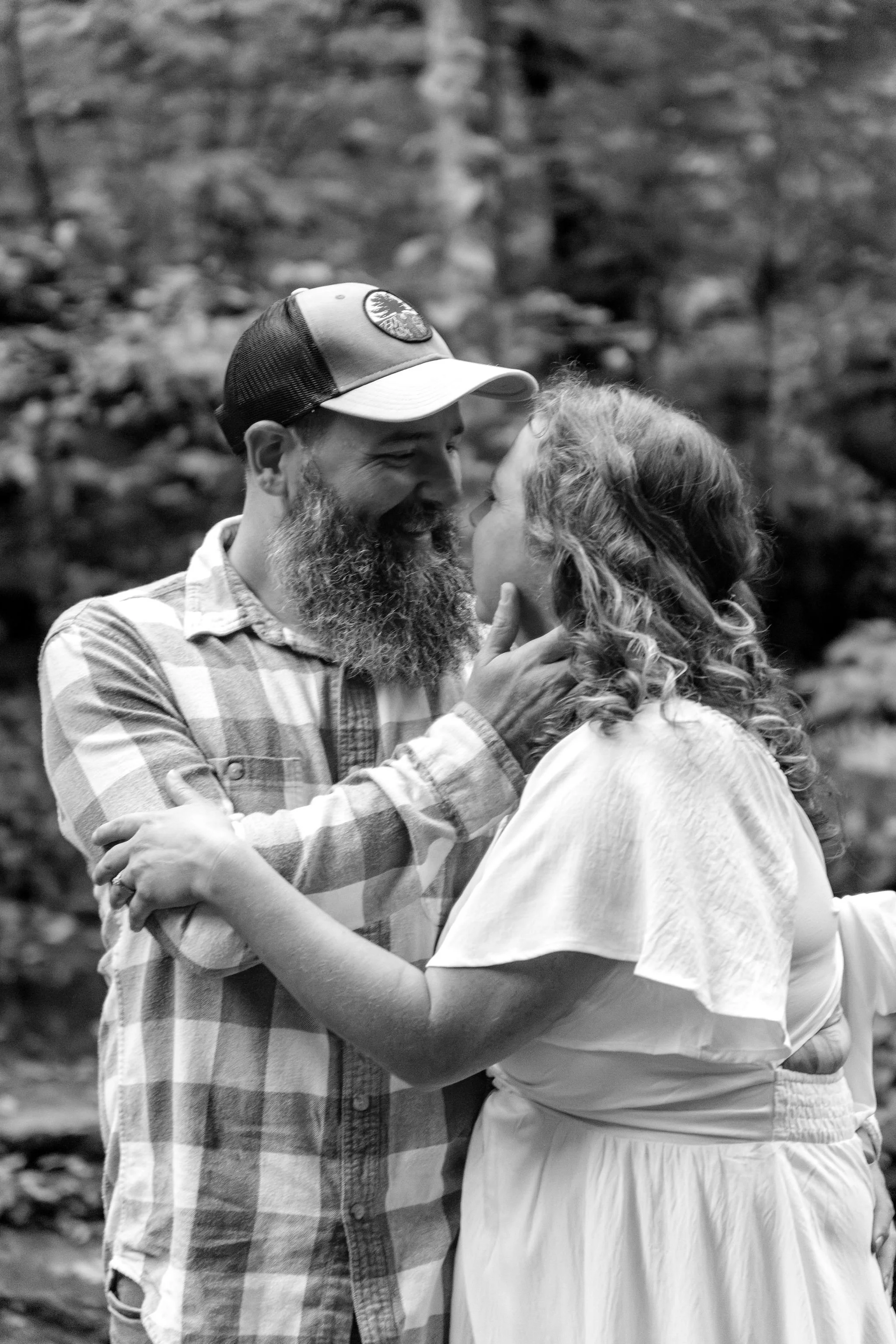 Black and white of Alison and Dave about to kiss beside the stone wall at Vaughan Woods in Hallowell Maine fall engagement photography VMG Productions
