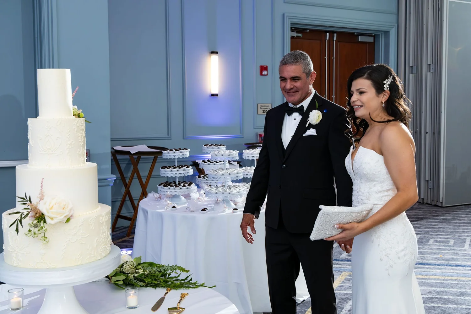 Nicole and Alexey seeing their wedding cake and dessert table at Portland Sheraton at Sable Oaks South Portland Maine summer wedding photography VMG Productions