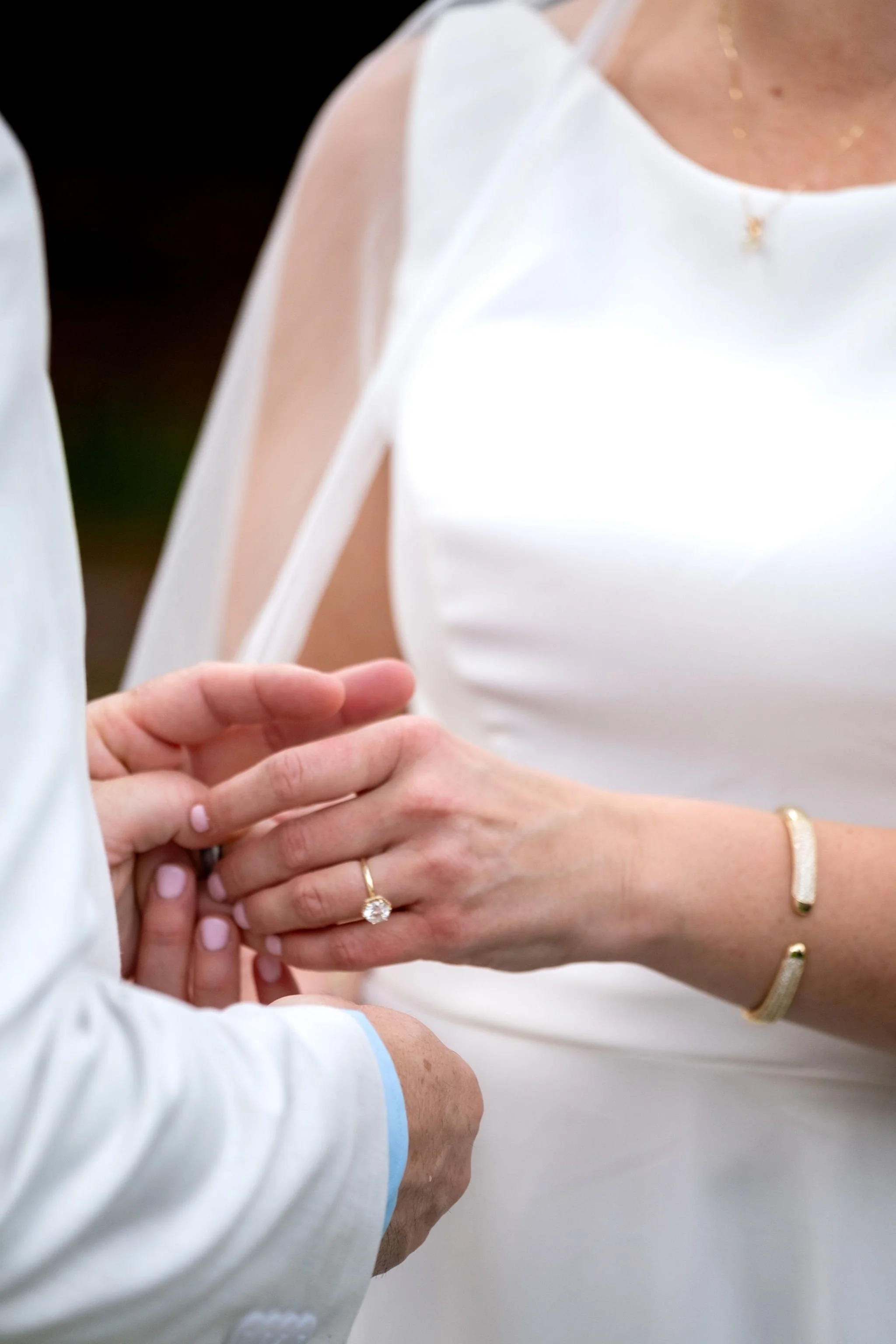 Ring exchange detail of Alli and Adam Baudoin's hands during their ceremony in Mount Desert Maine spring wedding photography VMG Productions