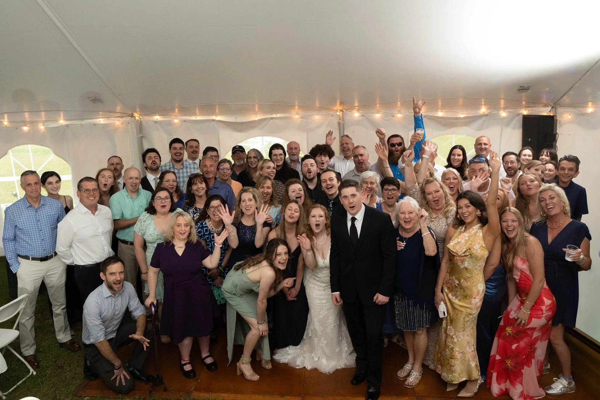 Kayla and Ethan DeAngelis full group photo with all their guests inside the reception tent at their Sanbornton New Hampshire wedding photography VMG Productions