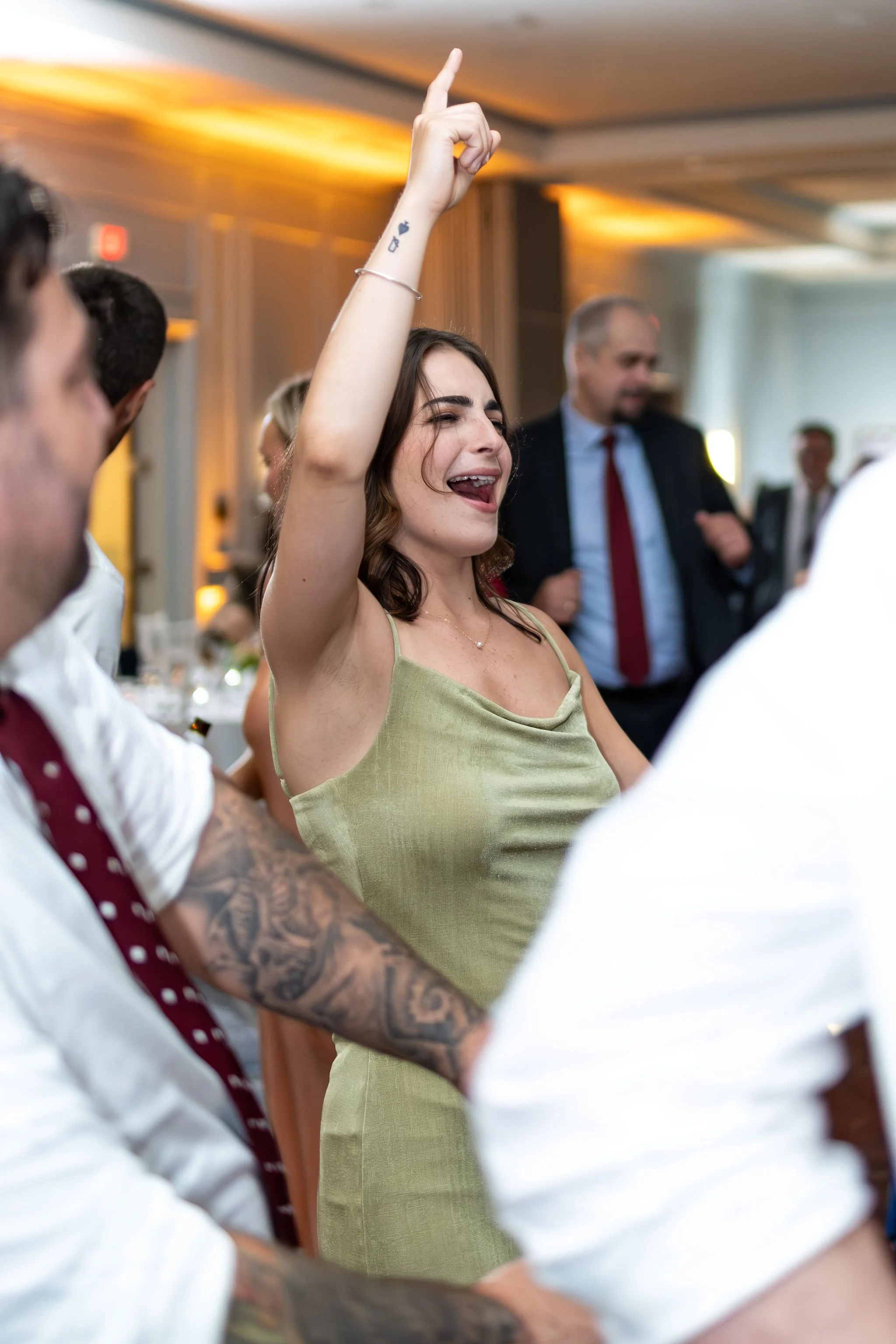 Nicole and Alexey raising their drinks to each other under the late night lights at Portland Sheraton at Sable Oaks South Portland Maine summer wedding photography VMG Productions
