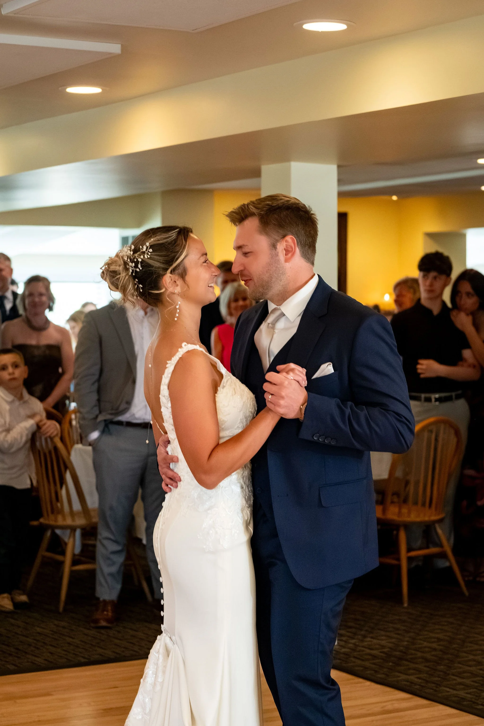 Beth and Cameron bride and groom smiling during their first dance at Augusta Country Club Manchester Maine spring wedding photography VMG Productions