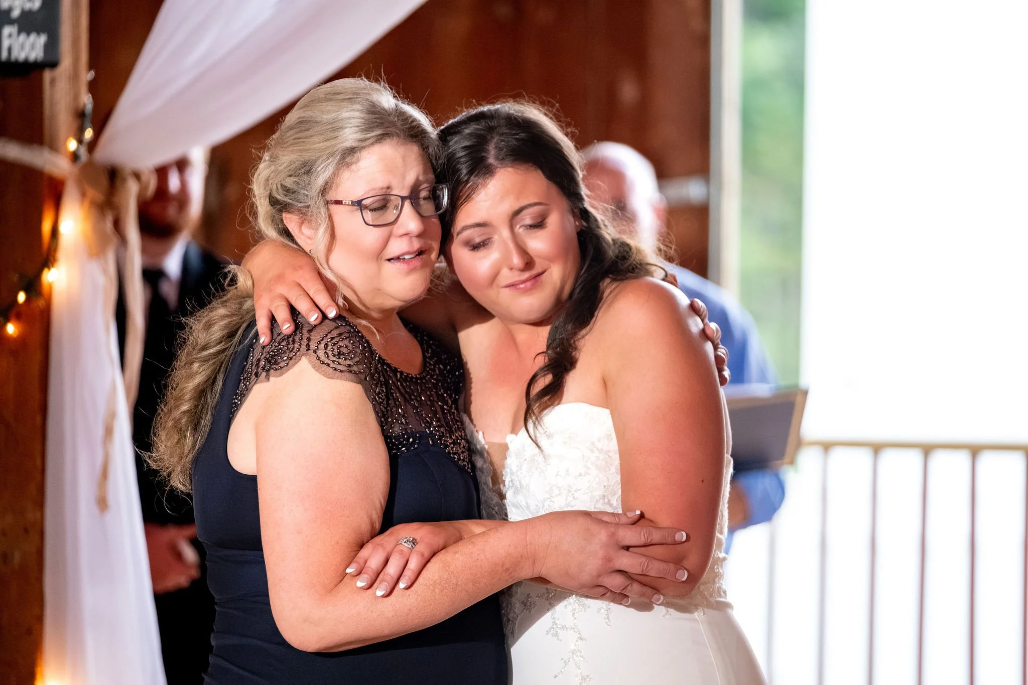 Alyssa and Colby the bride and her mom embracing as the parent dance comes to a close at the 1888 Barn Bethel Maine summer wedding photography VMG Productions