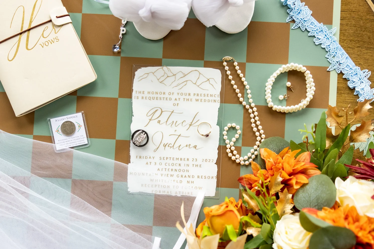 Wedding detail flat lay with invitation suite rings jewelry pearl necklace and autumn bouquet at Mountain View Grand Resort Whitefield New Hampshire