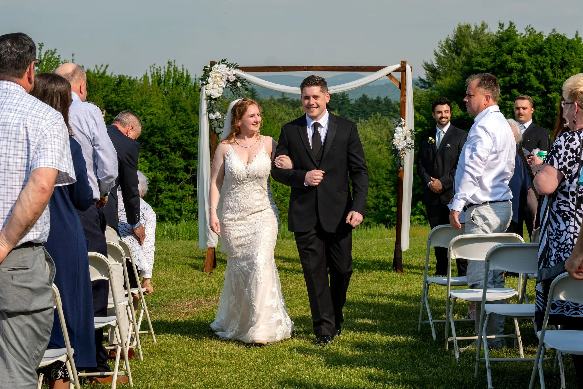 Kayla and Ethan DeAngelis ceremony guests standing and applauding at their Sanbornton New Hampshire backyard wedding photography VMG Productions