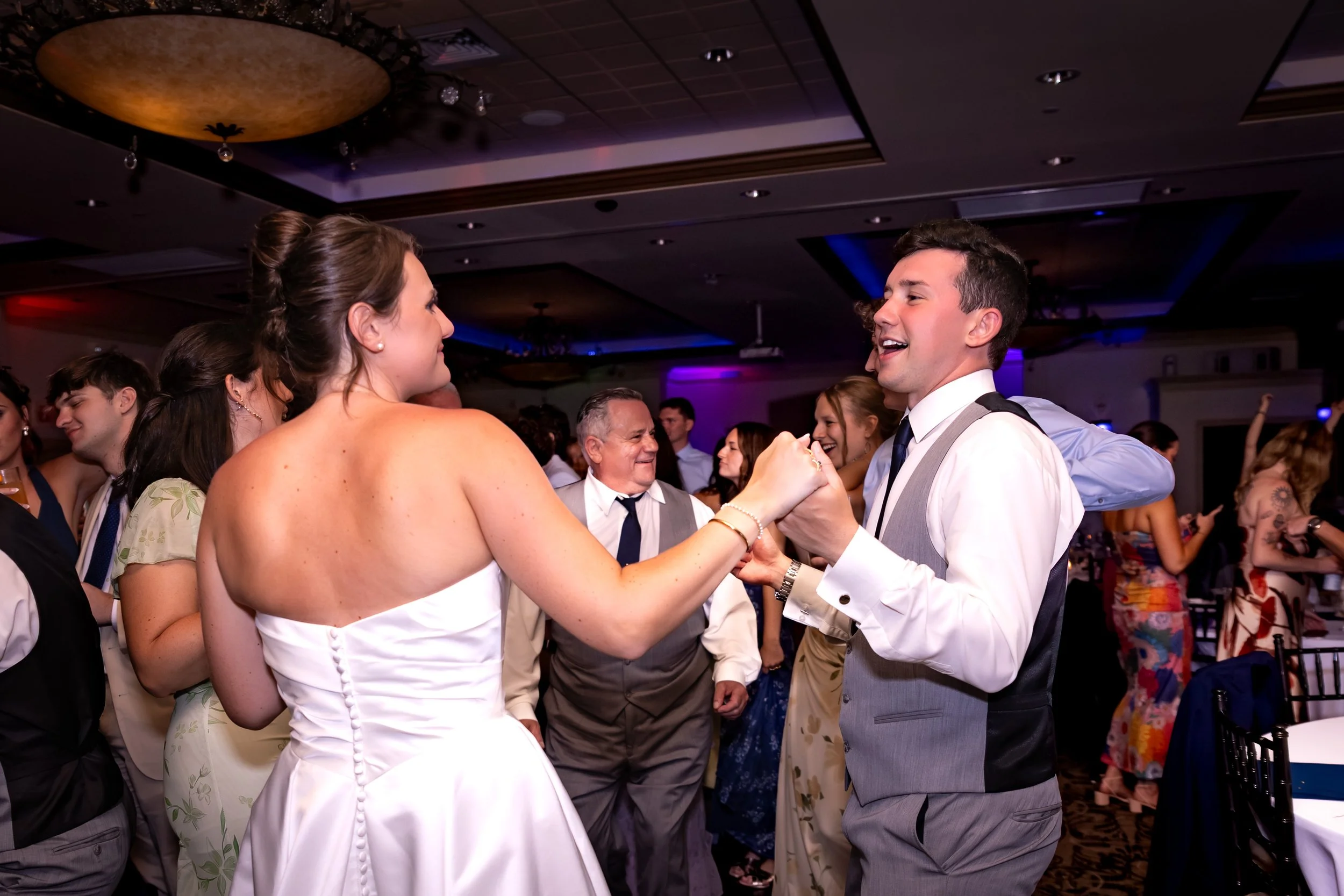 Caroline and Anthony Pirolli dancing together in the middle of the floor with bridesmaids and family around them at Union Bluff Hotel in York Maine wedding photography VMG Productions