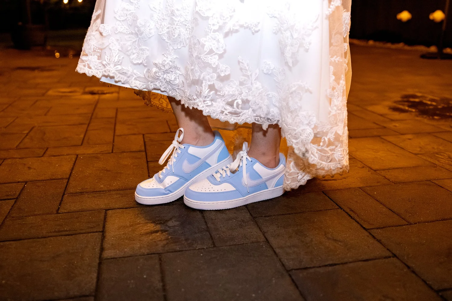 Bride wearing blue Nike sneakers under lace wedding dress at reception at The Barn at Hatch Point Bowdoinham Maine