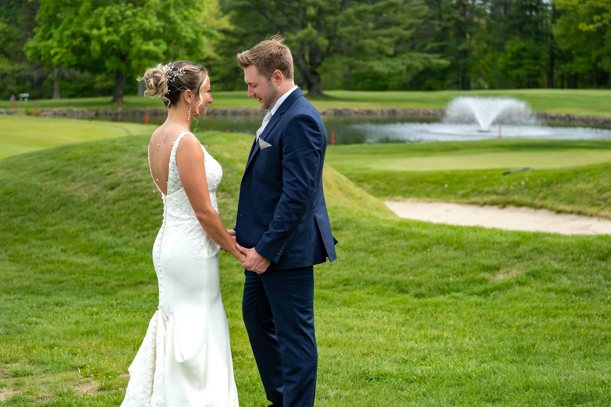 Beth and Cameron bride and groom at their first look by the pond fountain at Augusta Country Club Manchester Maine spring wedding photography VMG Productions